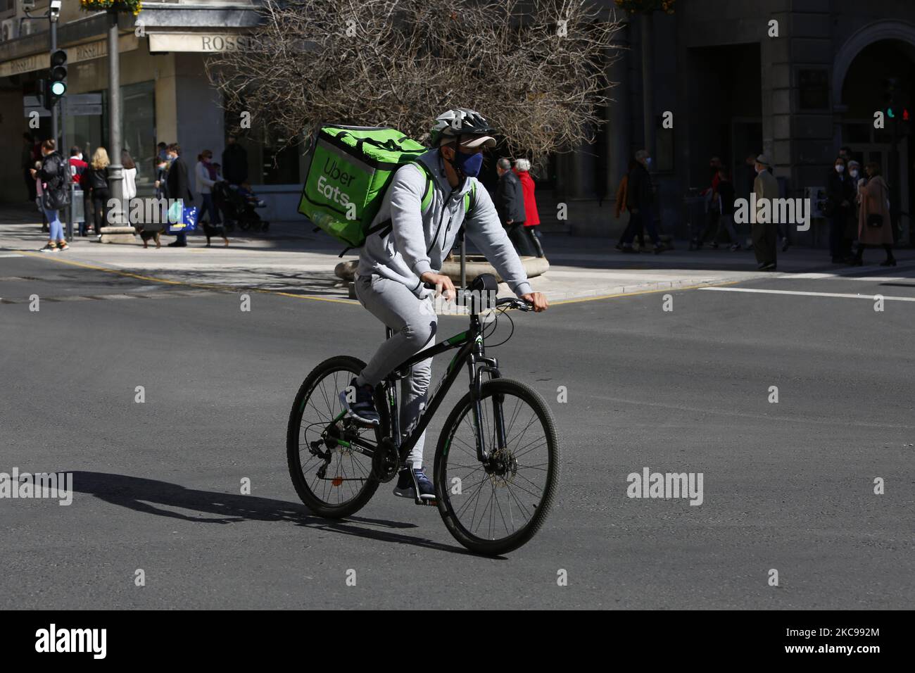 Ein Lieferer oder Fahrer aus Uber isst während eines sonnigen und warmen Valentinstags am 14. Februar 2021 in Granada, Spanien, auf dem Fahrrad. Granada, eine Provinz von Andalusien in Spanien, kämpft weiterhin gegen das Coronavirus, indem einige Maßnahmen wie eine Nachtruhe und Bars und Restaurants um 06:00 Uhr geschlossen werden, um die Virusinfektionen zu reduzieren. (Foto von Álex Cámara/NurPhoto) Stockfoto