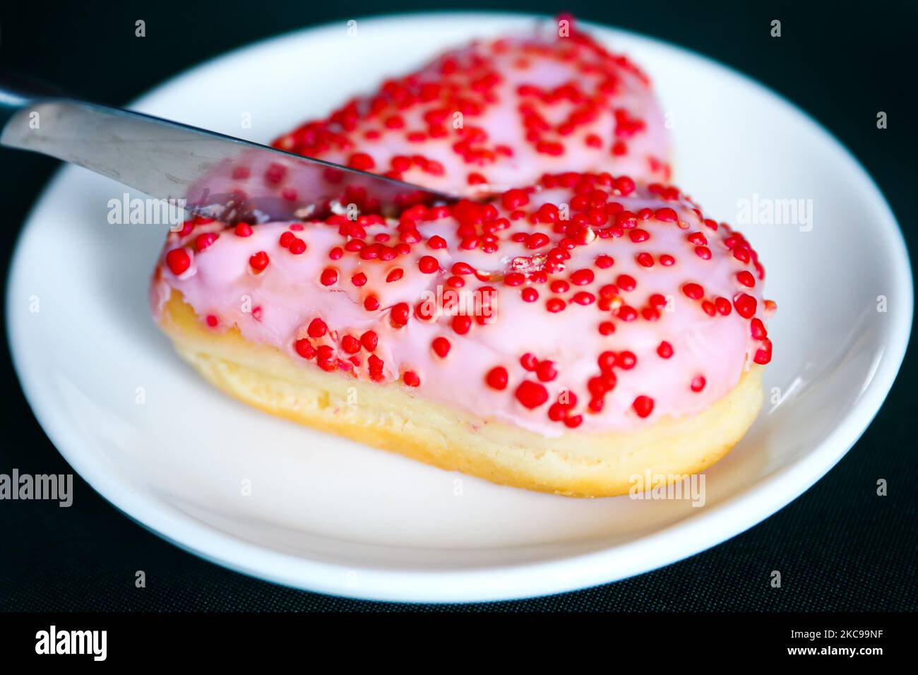 Ein in zwei Teile geschnittener herzförmiger Donut ist als Illustration des Valentinstag abgebildet. Krakau, Polen, am 14. Februar 2021. (Foto von Beata Zawrzel/NurPhoto) Stockfoto