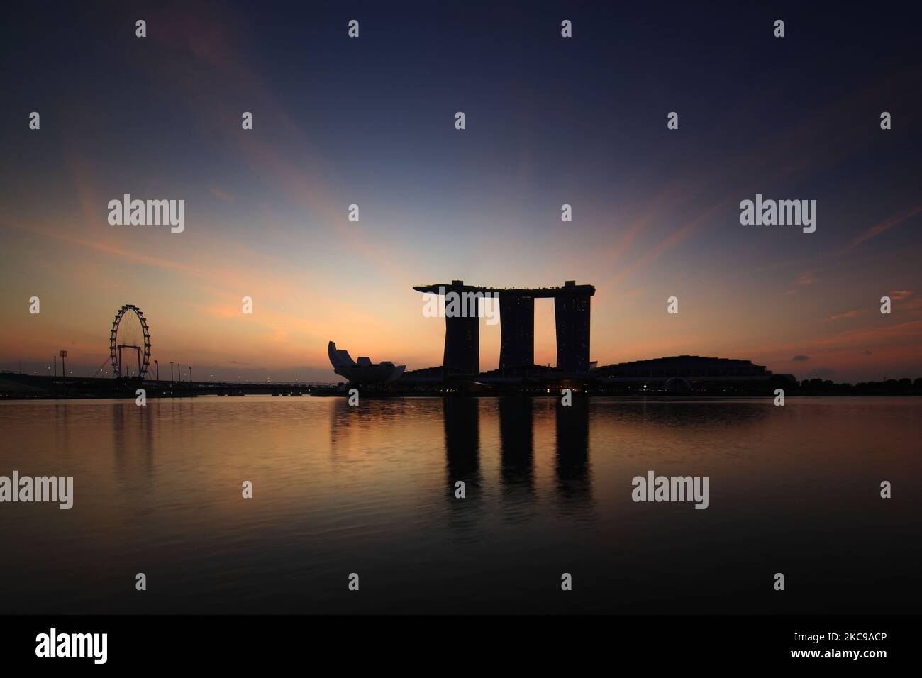 Eine allgemeine Ansicht des Singapore Flyer, des ArtScience Museums und des Marina Bay Sands während des Sonnenaufgangs in Marina Bay am 15. Februar 2021 in Singapur. (Foto von Suhaimi Abdullah/NurPhoto) Stockfoto