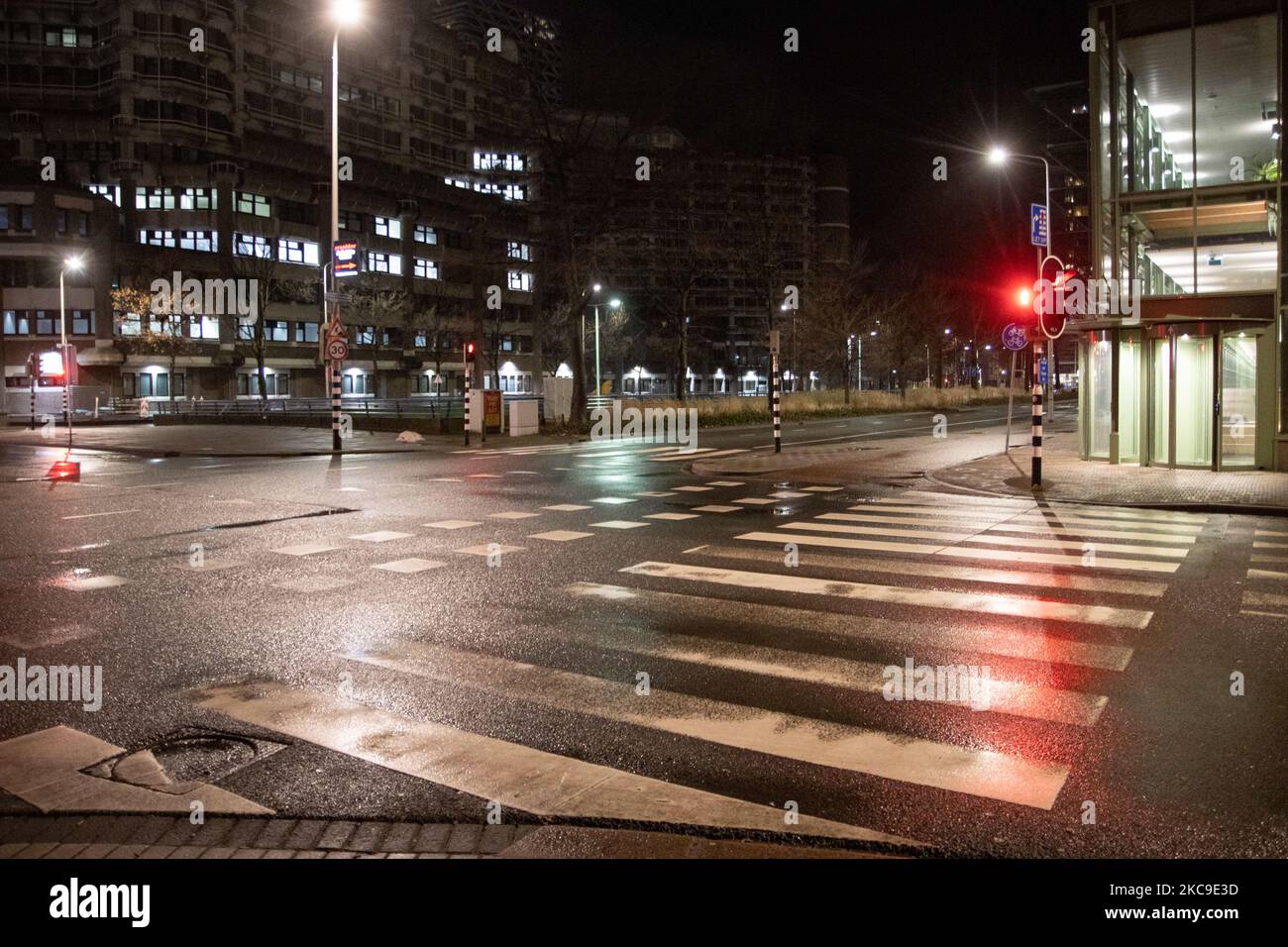 Verlassene und ruhige Straßen der niederländischen Stadt Den Haag oder Den Haag während der nächtlichen COVID-Sperrstunde in der Nähe der Gerichte Paleis van Justitie (Justizpalast) nach einer Berufung der Regierung gegen ein niedriges Gerichtsurteil zur Aufhebung der Sperrmaßnahme. Seit Januar können die Menschen nur noch mit einem erwiesenen Grund und einer Sondergenehmigung, gefolgt von einer ordnungsgemäßen Dokumentation, aus ihren Häusern ausziehen, ansonsten werden sie mit einer Geldstrafe von 95euro bestraft. Im ganzen Land wird die Polizei eingesetzt, um die Ausgangssperre zu überwachen. Leere und ruhige Straßen sind im Land zu sehen, im Gegensatz zu den gewalttätigen Protesten und Zusammenstößen in den frühen Tagen. Ausgangssperre wurde verhängt Stockfoto