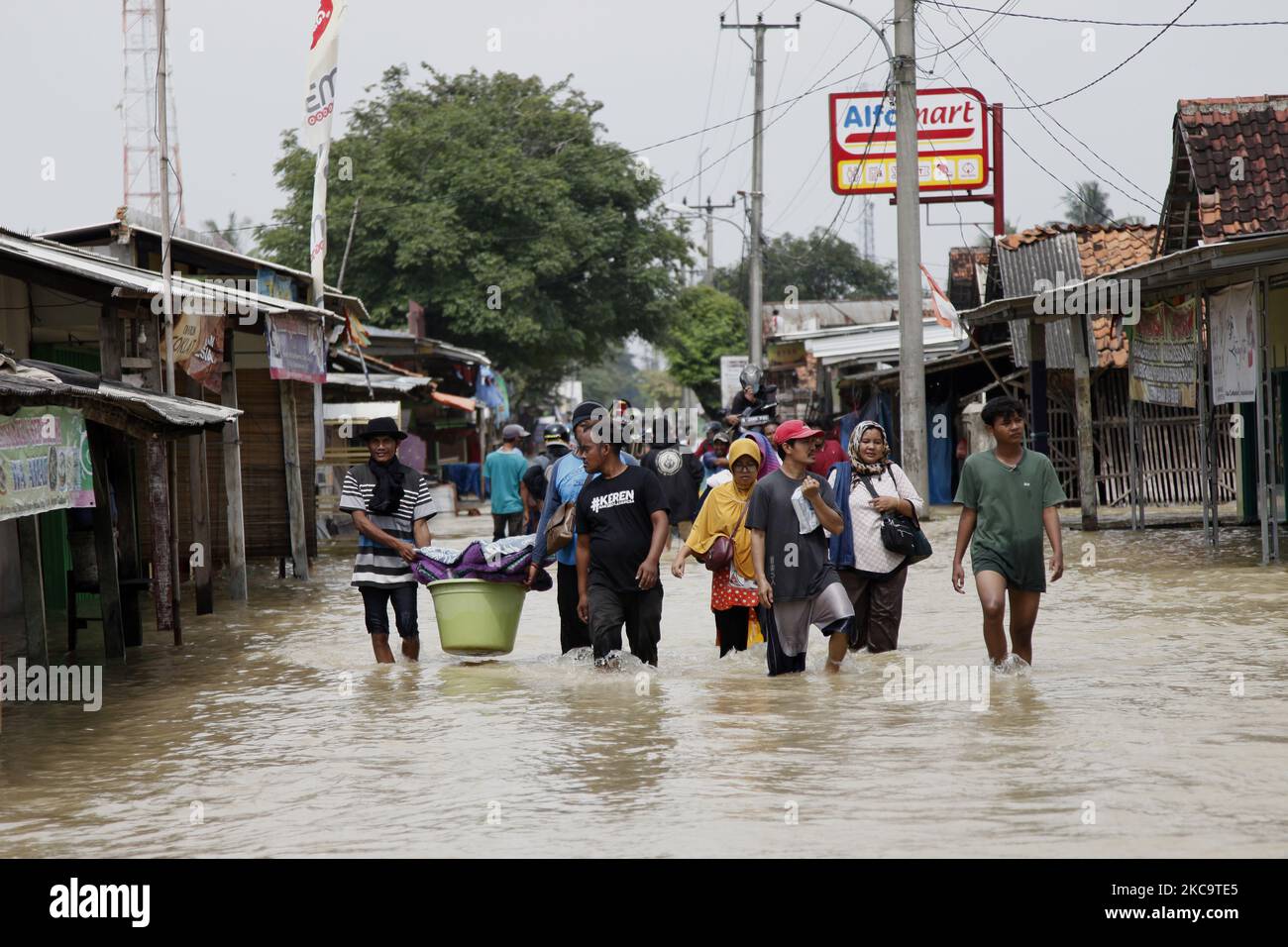 Bewohner, die am 22. Februar 2021 die Überschwemmungen im Teilbezirk Pebayuran, Bekasi-Regentschaft, West-Java, überquerten. Massive Überschwemmungen trafen eine Reihe von Dörfern in Bekasi Regentschaft, West-Java, nach starken Regenfällen, die in den letzten Tagen auftraten und einen Überlauf des Flusses Cibeet verursachten und den Citarum-Damm platzten. Mindestens 6,000 Familien waren von dieser Katastrophe betroffen. (Foto von Aditya Irawan/NurPhoto) Stockfoto