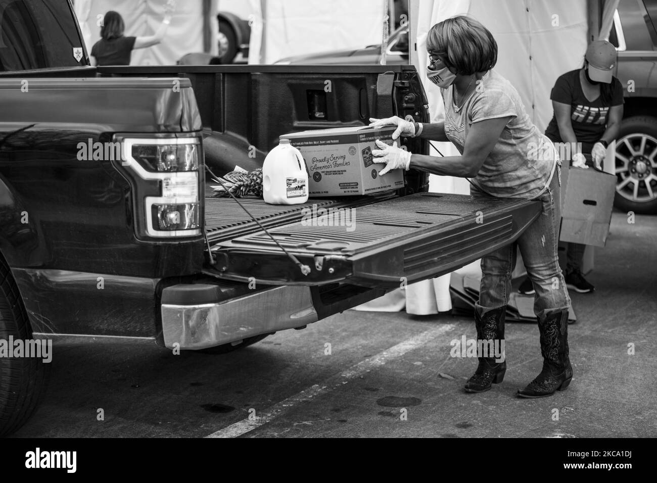 (ANMERKUNG DES HERAUSGEBERS: Bild wurde in Schwarz-Weiß umgewandelt) Ein Freiwilliger auf einem Gelände der Houston Food Bank im Freien arbeitet daran, Nahrungsmittel an Bedürftige zu verteilen, während die Stromkrise der letzten Woche am Nachmittag des Freitag, dem 26. Februar 2021, andauerte. (Foto von Reginald Mathalone/NurPhoto) Stockfoto