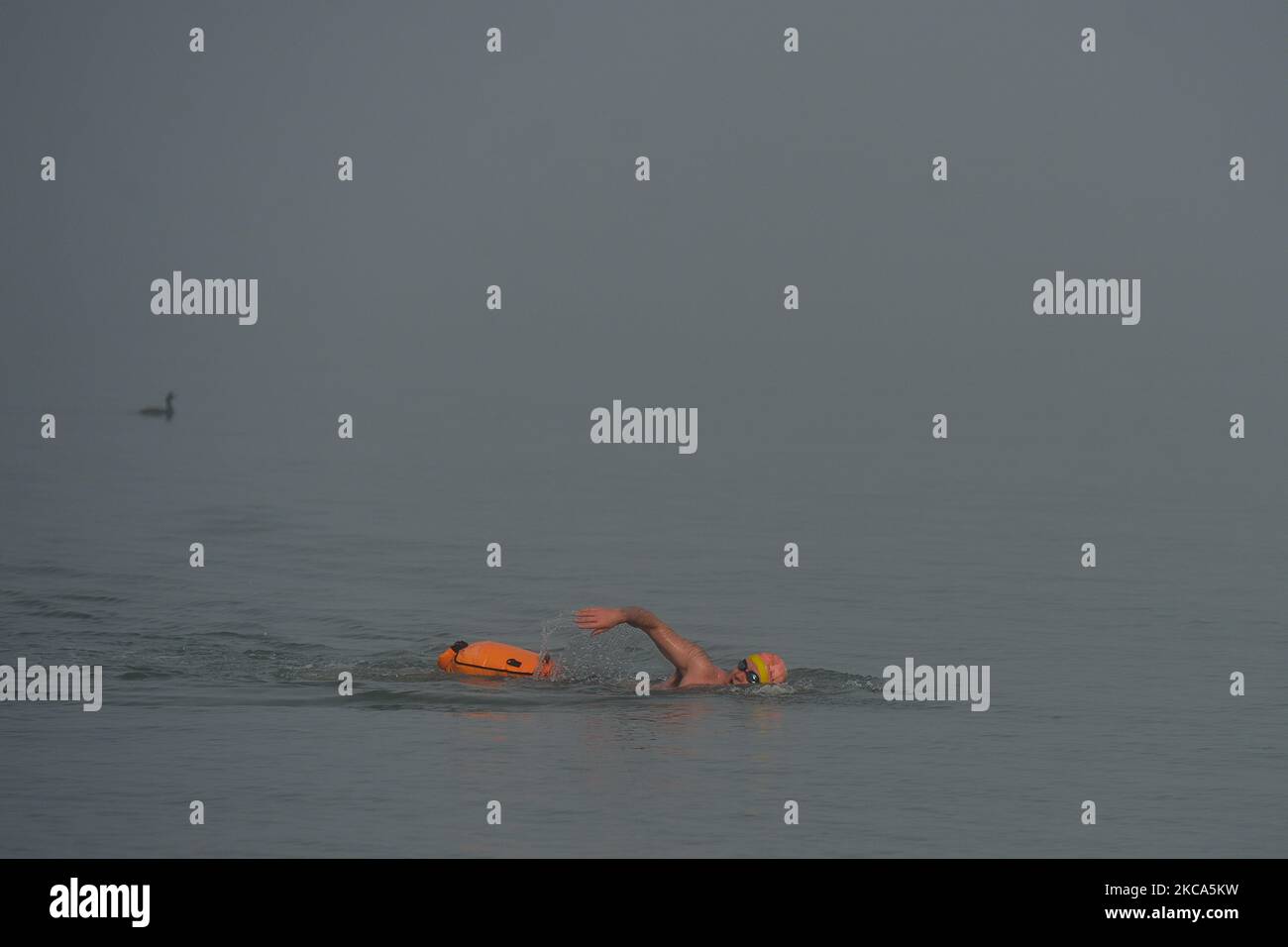 Ein Schwimmer, der vom Strand in der Nähe von Ballybrack aus gesehen wurde, während der Meeresnebel, der die Bucht von Dublin heute Morgen verdunkelte, die Sicht auf 50 Meter oder weniger reduzierte. Am Sonntag, den 28. Februar 2021, in Dublin, Irland. (Foto von Artur Widak/NurPhoto) Stockfoto