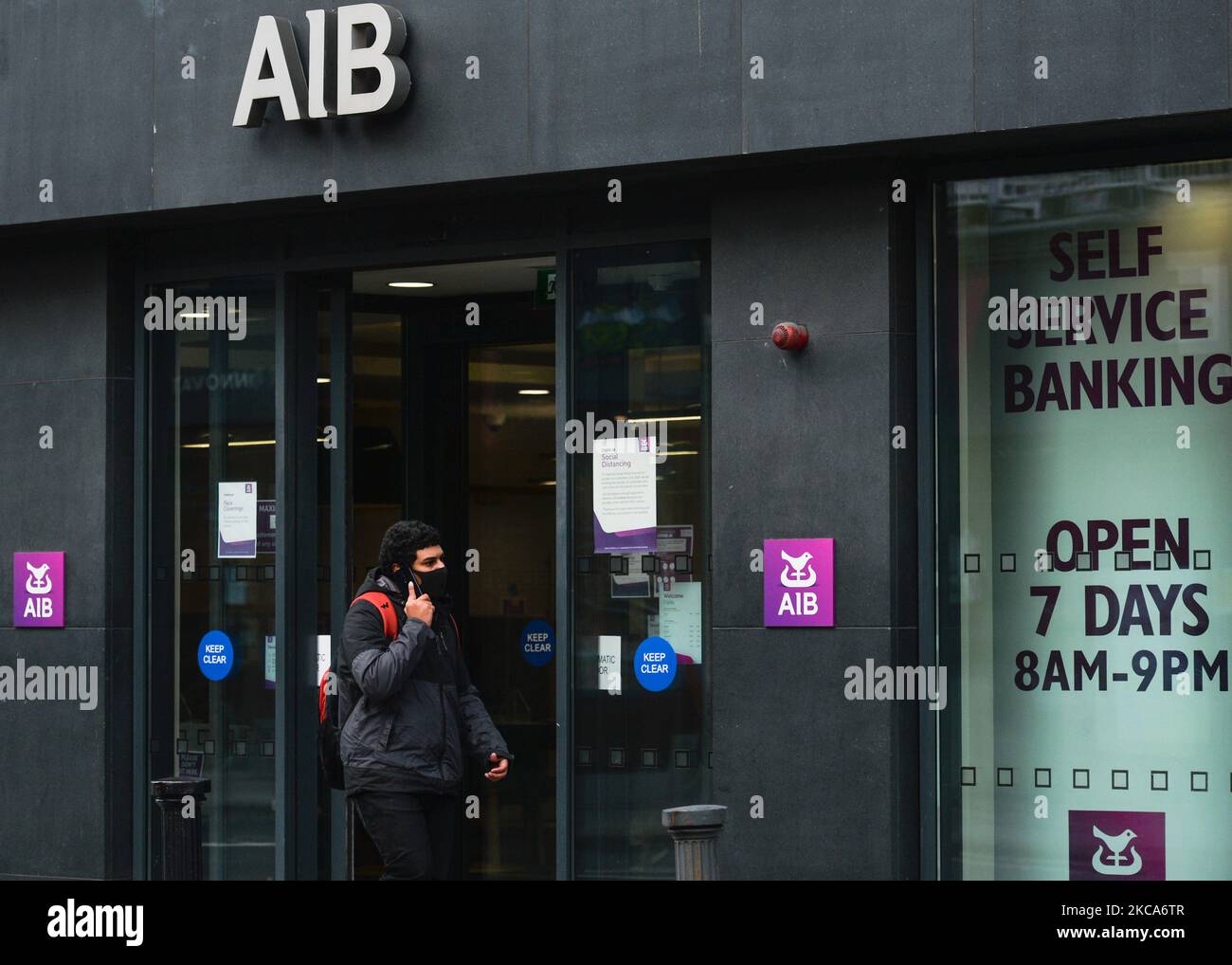 Ein Mann mit Gesichtsmaske kommt während der COVID-19-Sperre auf Level 5 an einer AIB-Niederlassung im Stadtzentrum von Dublin vorbei. Die Bank of Ireland gab heute die Schließung von 103 Filialen in ganz Irland bekannt, da die Beschleunigung des digitalen Bankwesens nun seinen „kritischen Punkt“ erreicht hat. Insgesamt werden 88 Filialen in der Republik Irland schließen, die 169 verlassen werden, und 15 Filialen in Nordirland werden die 13 schließen. Am Montag, den 1. März 2021, in Dublin, Irland. (Foto von Artur Widak/NurPhoto) Stockfoto