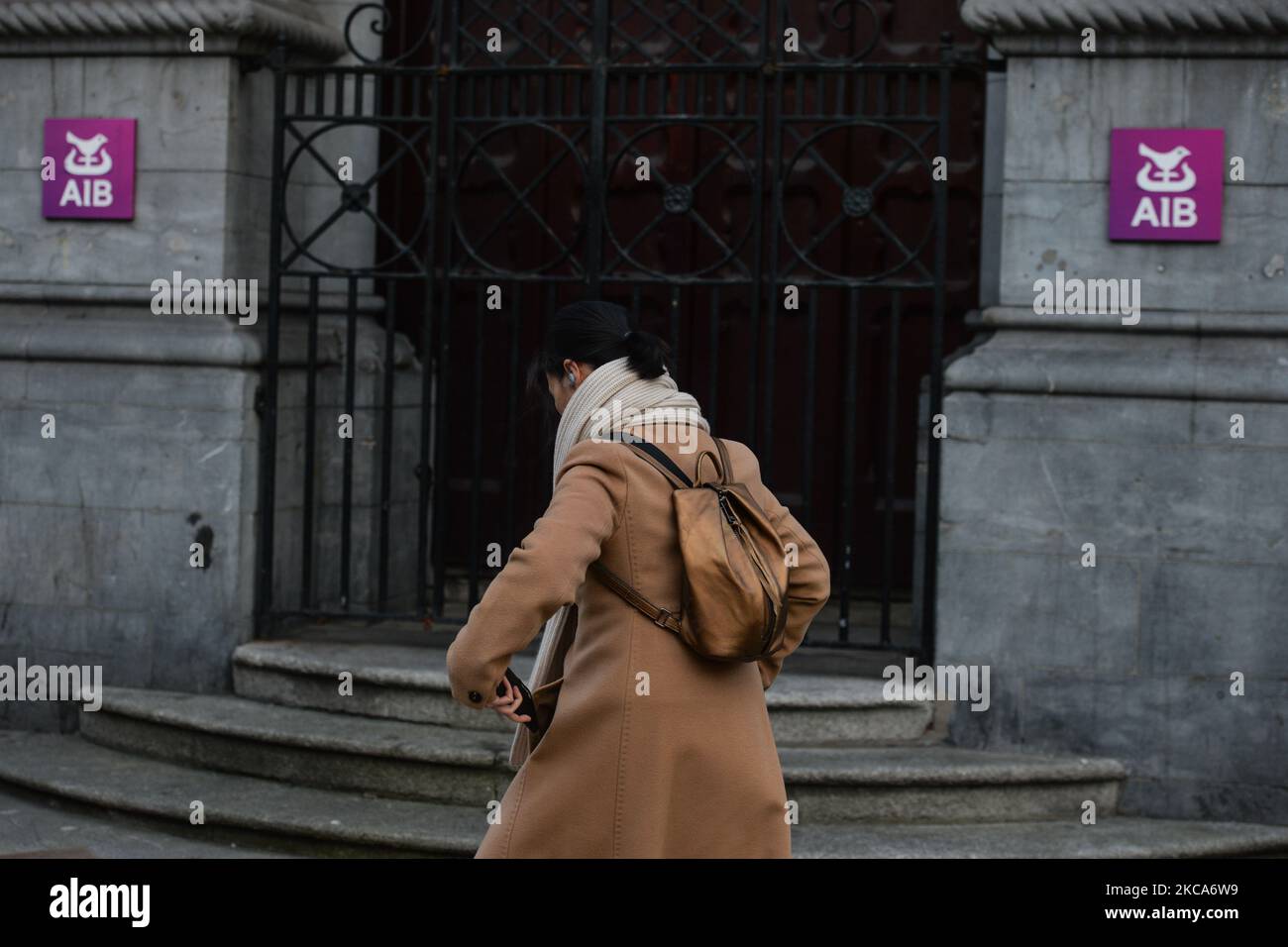 Eine Frau kommt während der COVID-19-Sperre auf Level 5 an einer AIB-Niederlassung im Stadtzentrum von Dublin vorbei. Die Bank of Ireland gab heute die Schließung von 103 Filialen in ganz Irland bekannt, da die Beschleunigung des digitalen Bankwesens nun seinen „kritischen Punkt“ erreicht hat. Insgesamt werden 88 Filialen in der Republik Irland schließen, die 169 verlassen werden, und 15 Filialen in Nordirland werden die 13 schließen. Am Montag, den 1. März 2021, in Dublin, Irland. (Foto von Artur Widak/NurPhoto) Stockfoto