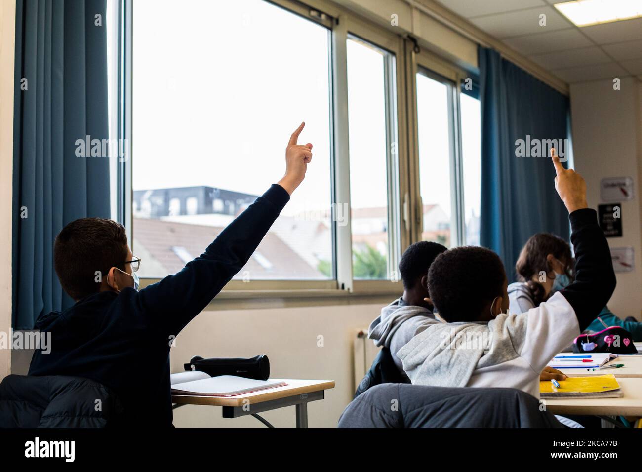 Chanteloup-les-Vignes, Frankreich, 4. Februar 2021. Kinder heben ihre Hände im Englischunterricht am Rene Cassin College. Diese Hochschule ist eine der Schulen, die vom Programm „les Cites educatives“ profitiert haben. Mit diesem Programm wird ein Aktionsplan zur Verringerung territorialer Ungleichheiten und zur Förderung des Erfolgs der Kinder aufgestellt. (Foto von Emeric Fohlen/NurPhoto) Stockfoto