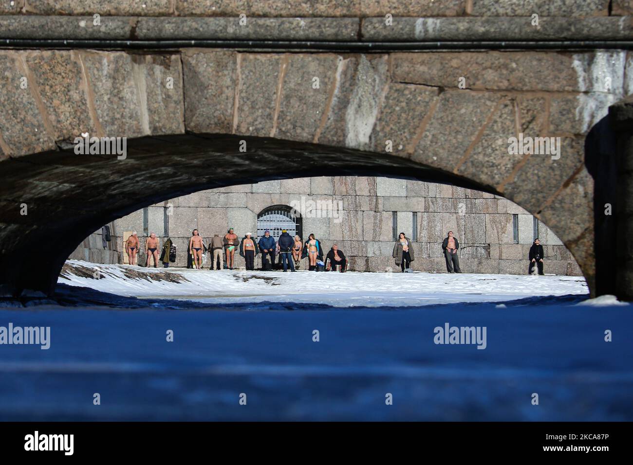 Am 2. März 2021 nehmen die Menschen ein Sonnenbad an der Mauer der Peter-Paul-Festung im Zentrum von St. Petersburg, Russland. Die Temperatur in der Stadt stieg auf +3 Grad (Foto: Valya Egorshin/NurPhoto) Stockfoto