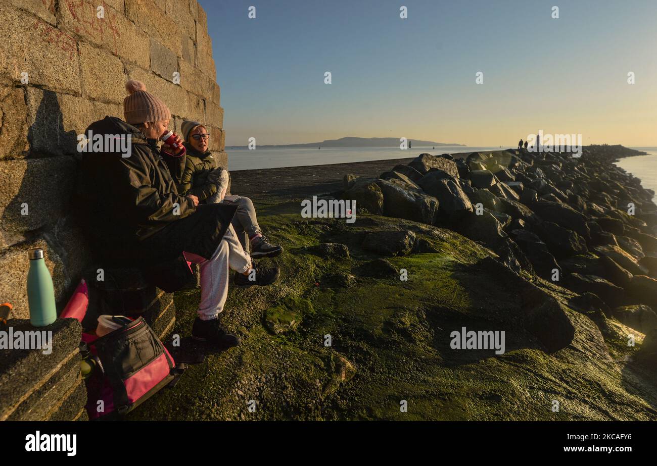 Schwimmer genießen ein heißes Getränk nach einem Sonnenuntergang schwimmen im Meer im Half Moon Swimming und Water Polo Club in Dublin, an der Great South Wall, während Level 5 Covid-19 Lockdown. Am Sonntag, den 7. März 2021, in Dublin, Irland. (Foto von Artur Widak/NurPhoto) Stockfoto