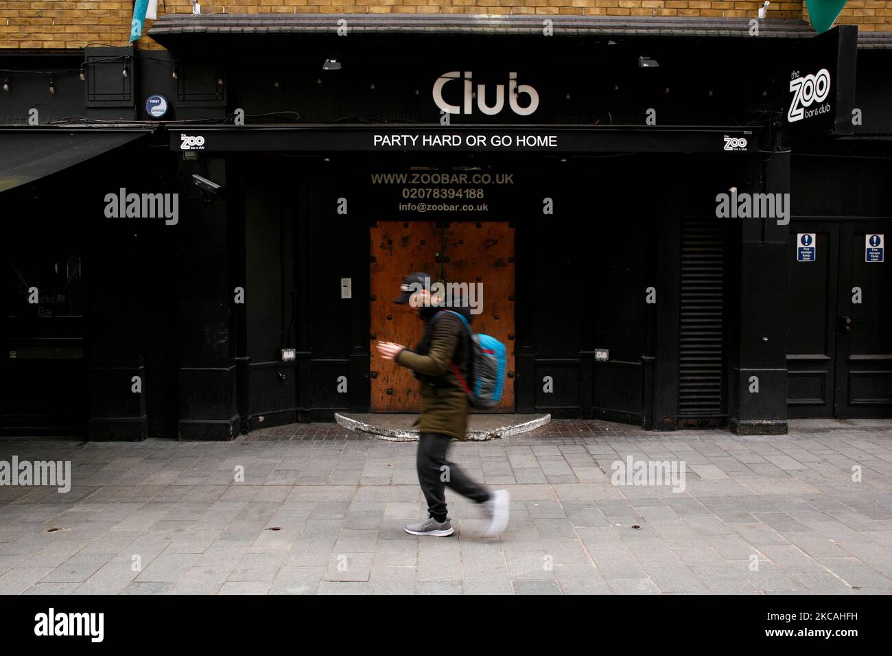 Am 8. März 2021 geht ein Mann an einer geschlossenen Bar und einem Club in der Bear Street neben dem Leicester Square in London, England, vorbei. Heute war die erste Phase der Lockerung des Coronavirus in ganz England, mit der Wiedereröffnung der Schulen und einer Lockerung einiger Grenzen für den sozialen Kontakt. Geschäfte, Bars, Restaurants und andere Gaststätten, die nicht unbedingt notwendig sind, bleiben jedoch geschlossen und werden nach dem aktuellen Zeitplan erst im nächsten Monat wieder eröffnet. (Foto von David Cliff/NurPhoto) Stockfoto