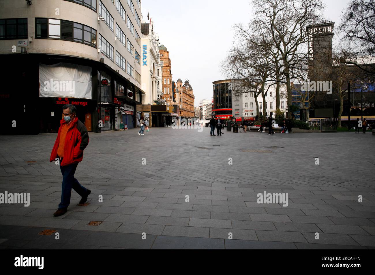 Ein Mann mit Gesichtsmaske geht am 8. März 2021 an geschlossenen Kinos, Kasinos und Restaurants auf dem nahe verlassenen Leicester Square in London, England, vorbei. Heute war die erste Phase der Lockerung des Coronavirus in ganz England, mit der Wiedereröffnung der Schulen und einer Lockerung einiger Grenzen für den sozialen Kontakt. Geschäfte, Bars, Restaurants und andere Gaststätten, die nicht unbedingt notwendig sind, bleiben jedoch geschlossen und werden nach dem aktuellen Zeitplan erst im nächsten Monat wieder eröffnet. (Foto von David Cliff/NurPhoto) Stockfoto