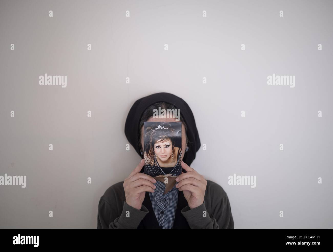 Masoumeh Ataei, die Opfer eines sauren Angriffs ist, hält ihr Porträt, das sie vor dem Angriff gemacht hat, während sie am 9. März 2021 in ihrer Wohnung im Stadtteil Parand in der Stadt Robatkarim in der Provinz Teheran für ein Foto posiert. Vor zehn Jahren, eineinhalb Jahre nachdem Masoumeh Ataei sich von ihrem Mann scheiden ließ, verlor sie nach einem sauren Angriff ihres Schwiegervaters ihr Gesicht und ihr Augenlicht, aber sie musste ihm aus einem persönlichen Grund vergeben, Jetzt nach zehn Jahren muss sie nach Großbritannien gehen und muss 70.000 GBP für die Operationskosten einsammeln, wenn sie wieder sehend werden will. (P Stockfoto