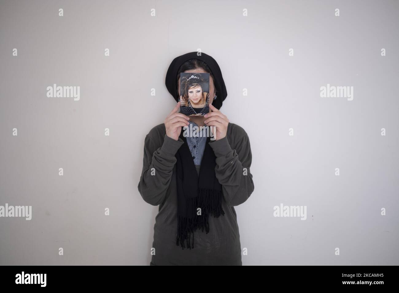 Masoumeh Ataei, die Opfer eines sauren Angriffs ist, hält ihr Porträt, das sie vor dem Angriff gemacht hat, während sie am 9. März 2021 in ihrer Wohnung im Stadtteil Parand in der Stadt Robatkarim in der Provinz Teheran für ein Foto posiert. Vor zehn Jahren, eineinhalb Jahre nachdem Masoumeh Ataei sich von ihrem Mann scheiden ließ, verlor sie nach einem sauren Angriff ihres Schwiegervaters ihr Gesicht und ihr Augenlicht, aber sie musste ihm aus einem persönlichen Grund vergeben, Jetzt nach zehn Jahren muss sie nach Großbritannien gehen und muss 70.000 GBP für die Operationskosten einsammeln, wenn sie wieder sehend werden will. (P Stockfoto