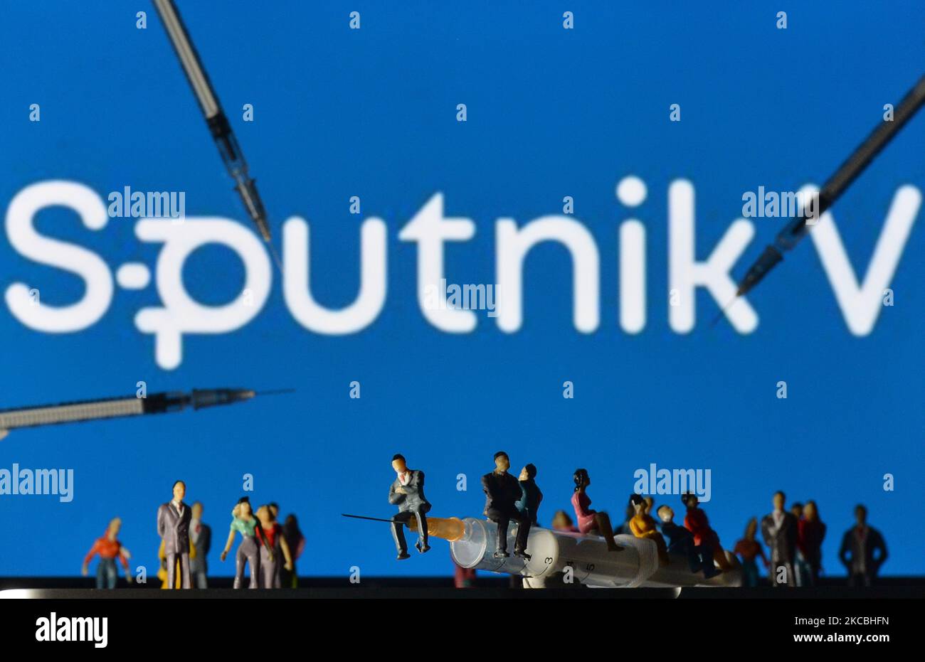 Medizinische Spritzen und kleine Figuren von Menschen sind vor dem Sputnik V-Logo auf einem Bildschirm zu sehen. Am Samstag, den 26. März 2021, in Dublin, Irland. (Foto von Artur Widak/NurPhoto) Stockfoto