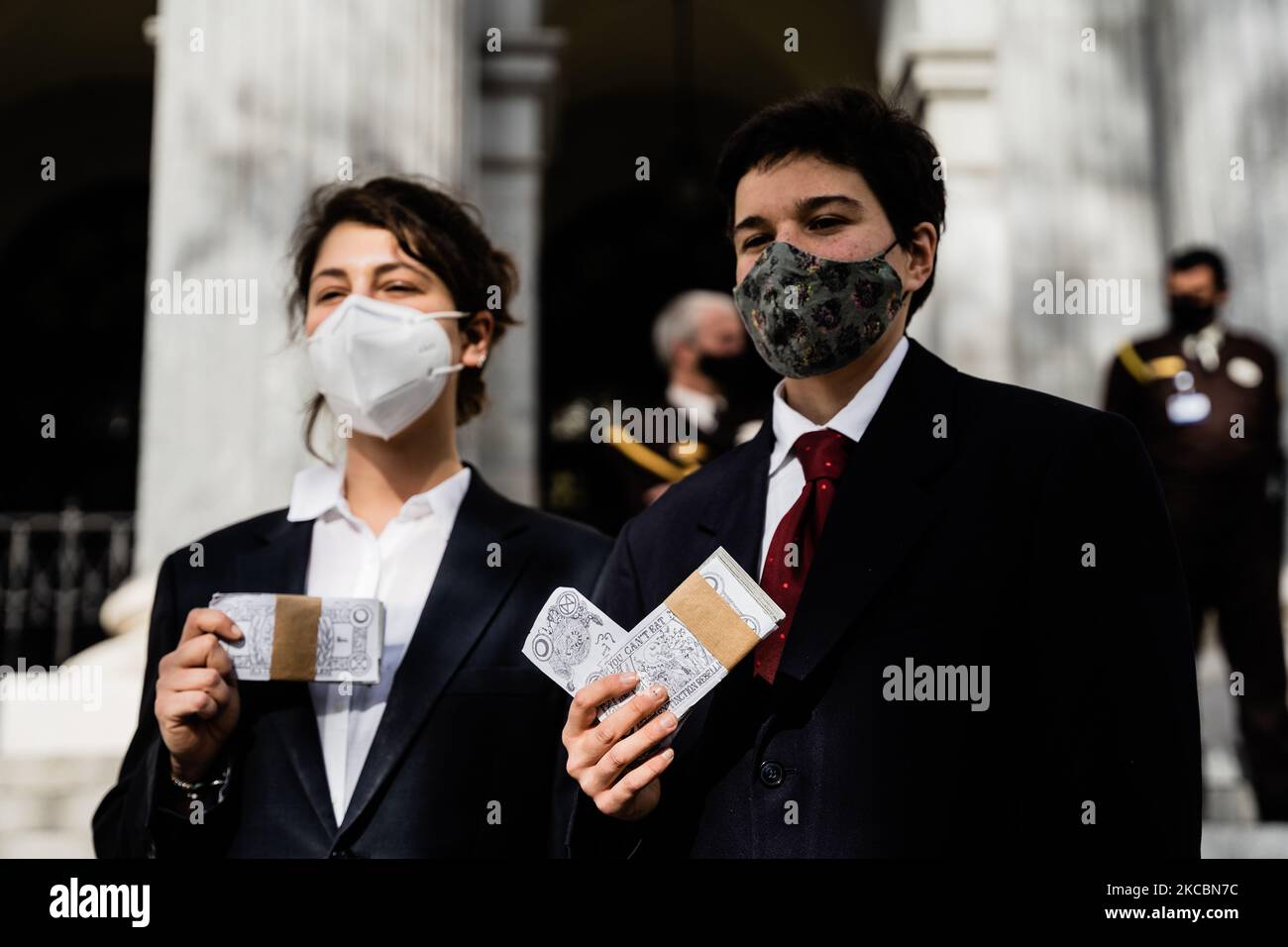 In einer Aktion heute Nachmittag vor der Madrider Börse prangern Friends of the Earth and Extinction Rebellion (XR) die Gefahr der Kommodifizierung und Spekulation mit einem Grundgut wie Wasser an. Auf dem Bild sehen Sie einige Aktivisten, die als Banker verkleidet sind und Geldscheinbündel halten. Durch diese Aktion wollen die Organisationen vor dem gefährlichen Präzedenzfall warnen, der durch den kalifornischen Wasserpreis auf dem Wall Street Futures-Markt seit dem letzten Dezember festgelegt wurde. In Madrid, Spanien, am 22. März 2021. (Foto von Jon Imanol Reino/NurPhoto) Stockfoto