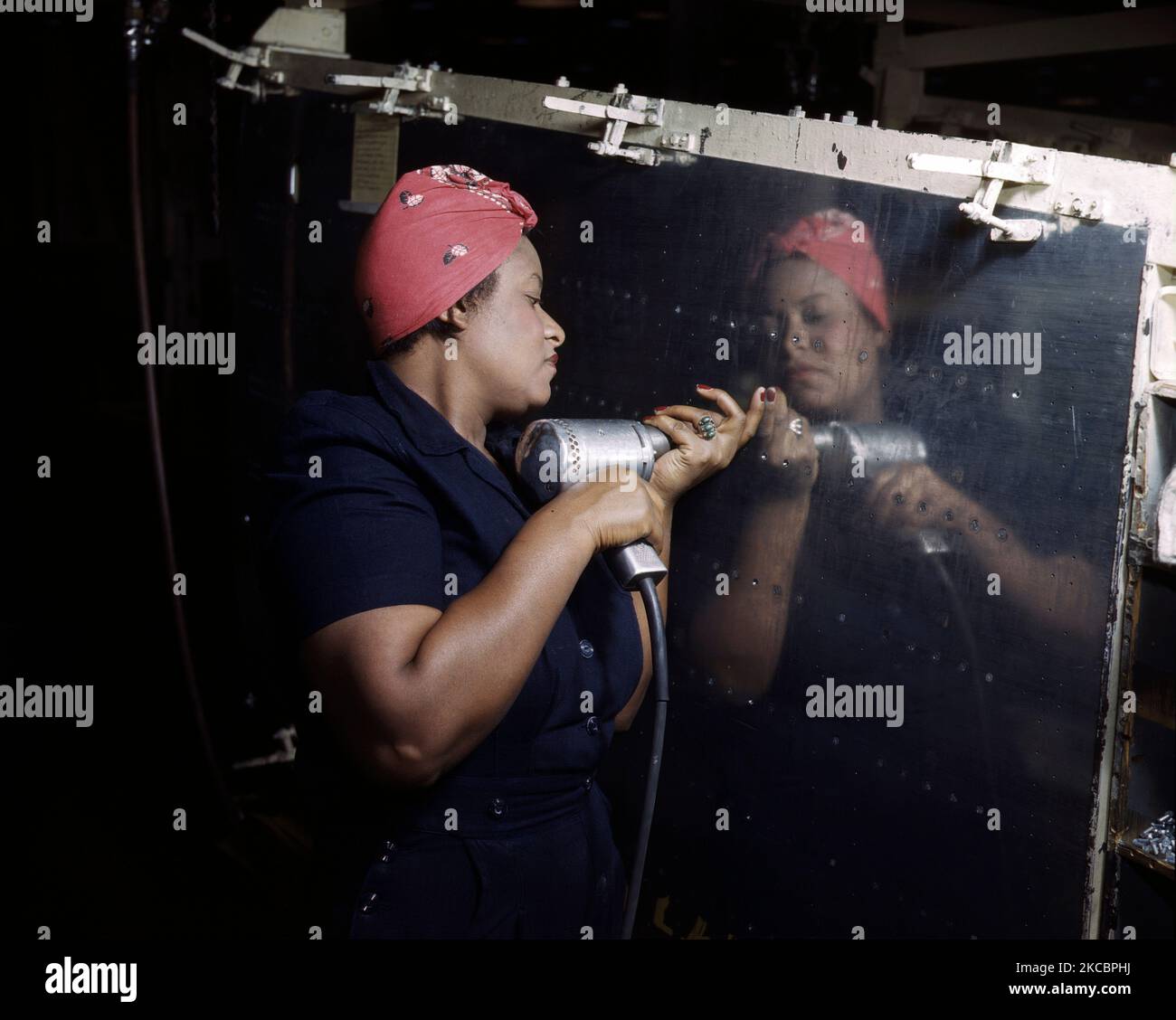 Eine Arbeiterin der Fabrik, die während des Zweiten Weltkriegs 1943 einen Handbohrer an einem A-31 Vengeance Dive Bomber angriff. Stockfoto