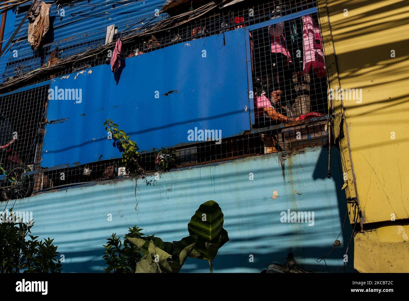 Eine Frau guckt am 30. März 2021 aus ihrem Haus in der Stadt Mandaluyong, östlich von Manila, aus ihrem Fenster. Das philippinische Gesundheitsministerium empfahl eine Verlängerung der strengeren Quarantäne der Gemeinschaft, die jetzt in der Hauptstadtregion und einigen umliegenden Provinzen in Kraft ist, um den Anstieg von COVID19 Fällen zu stoppen. Die Philippinen haben in den letzten Tagen Rekordzahlen an Infektionen erfasst, was Gesundheitsexperten und die breite Öffentlichkeit alarmierend macht. (Foto von George Calvelo/NurPhoto) Stockfoto