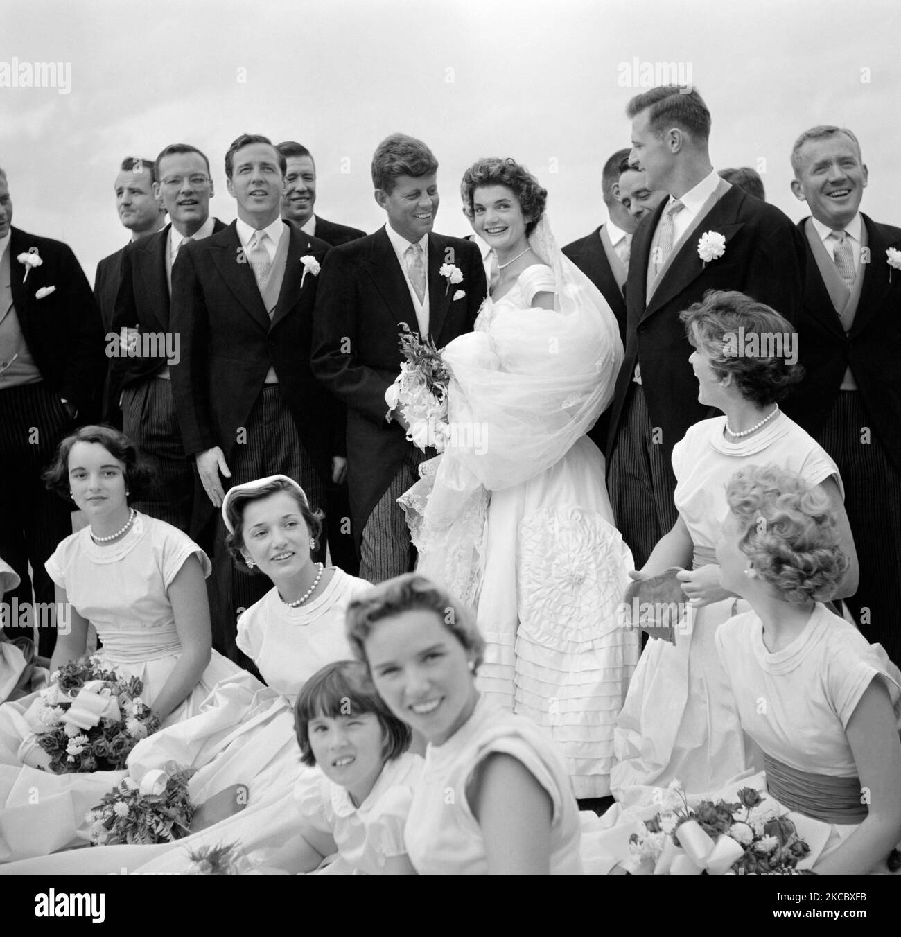 Jackie Bouvier Kennedy und John F. Kennedy umgeben von ihrer Hochzeitsfeier. Stockfoto