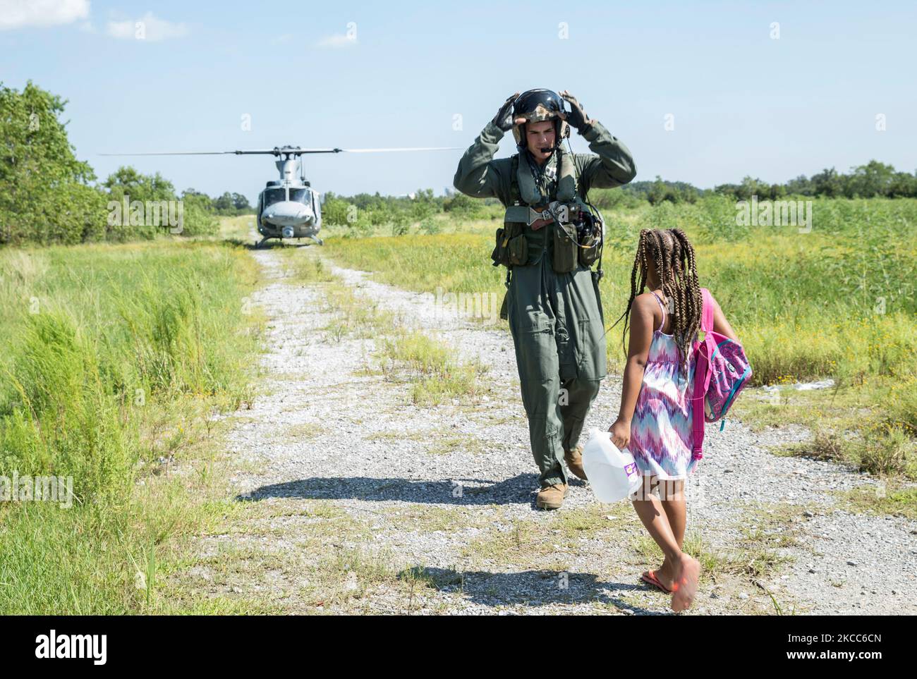 Eine US-Marine führt ein Kind während einer Hurrian Harvey-Rettungsmission zu einem UH-1Y-Hubschrauber. Stockfoto