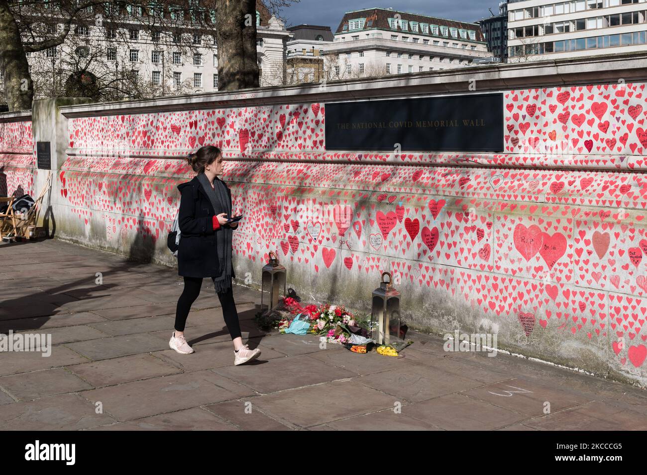 LONDON, GROSSBRITANNIEN - 07. APRIL 2021: Ein Mitglied der Öffentlichkeit kommt am 07. April 2021 in London, England, an einem Denkmal für die Opfer von Covid-19 vor dem St. Thomas’ Hospital vorbei. Das Wandbild, das Covid-19 Hinterbliebene Familien für Gerechtigkeit am Montag vergangener Woche eingerichtet hat, hat bisher rund 130.000 handgezeichnete Herzen auf einem kilometerlangen Mauerabschnitt vor dem Parlament gesehen. (Foto von Wiktor Szymanowicz/NurPhoto) Stockfoto