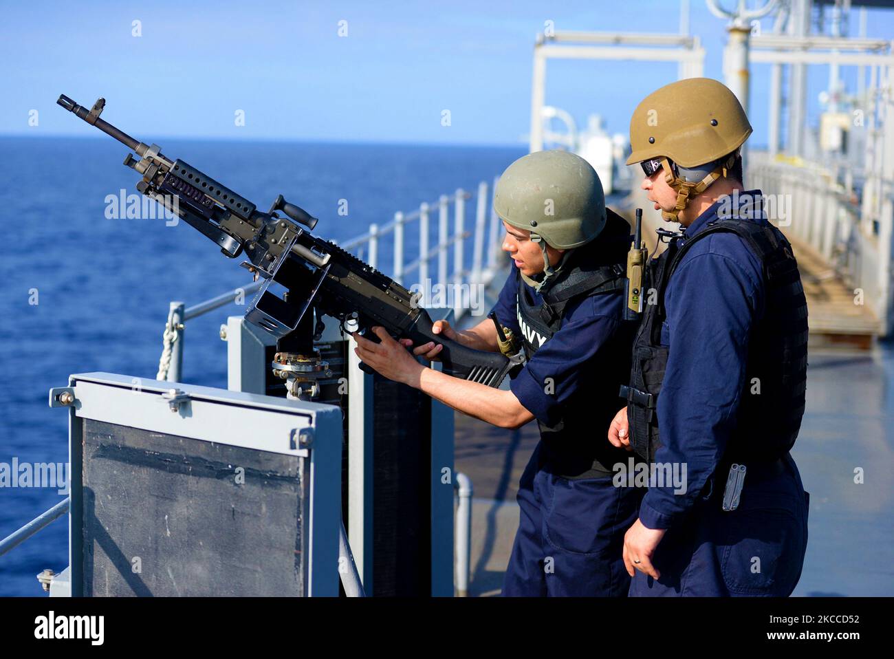 Der Militärangehöriger des Schiffes bereitet sich darauf vor, ein Maschinengewehr von M240B abzufeuern. Stockfoto