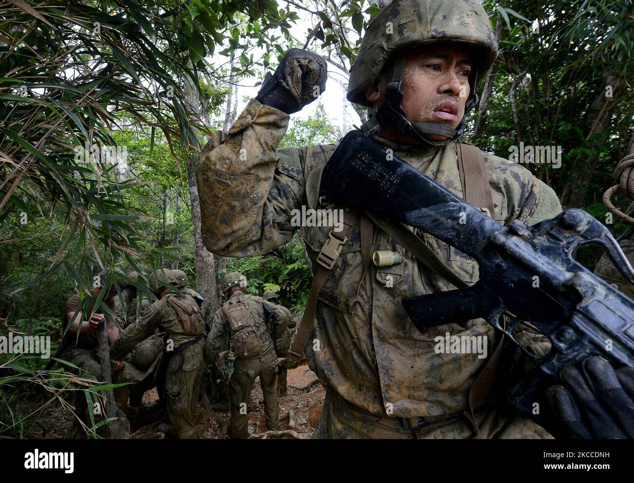 Ein Seabee sichert sich das Heck seiner Patrouille einen steilen Hügel in Japan hinunter. Stockfoto