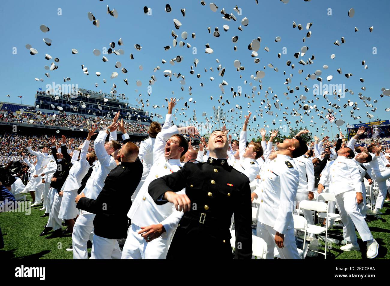 Midshipmänner der U.S. Naval Academy werfen ihre Abdeckungen während der Abschlussfeier in die Luft. Stockfoto