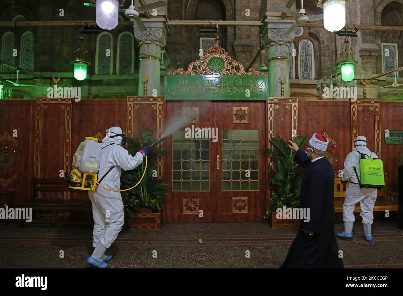 Arbeiter, die Gesichtsmasken tragen, sprühen Desinfektionsmittel, während sie sich während des gesegneten Monats Ramadan in der Sayeda Zeinab Moschee nach dem Ausbruch des Coronavirus (Covid-19) in Kairo, Ägypten, am 9. April 2021 auf das Gebet vorbereiten. (Foto von Fadel Dawod/NurPhoto) Stockfoto