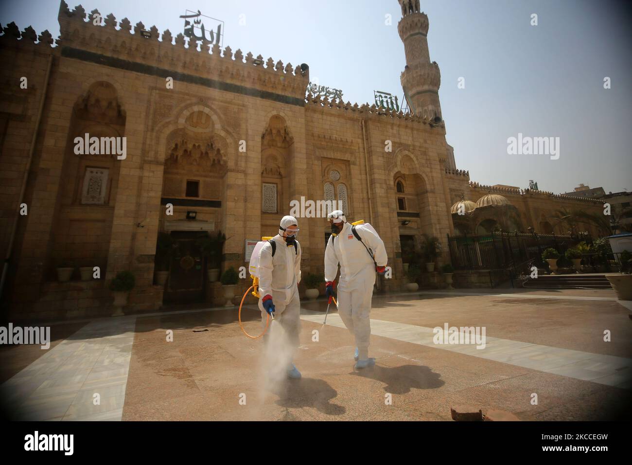 Arbeiter, die Gesichtsmasken tragen, sprühen Desinfektionsmittel, während sie sich während des gesegneten Monats Ramadan in der Sayeda Zeinab Moschee nach dem Ausbruch des Coronavirus (Covid-19) in Kairo, Ägypten, am 9. April 2021 auf das Gebet vorbereiten. (Foto von Fadel Dawod/NurPhoto) Stockfoto