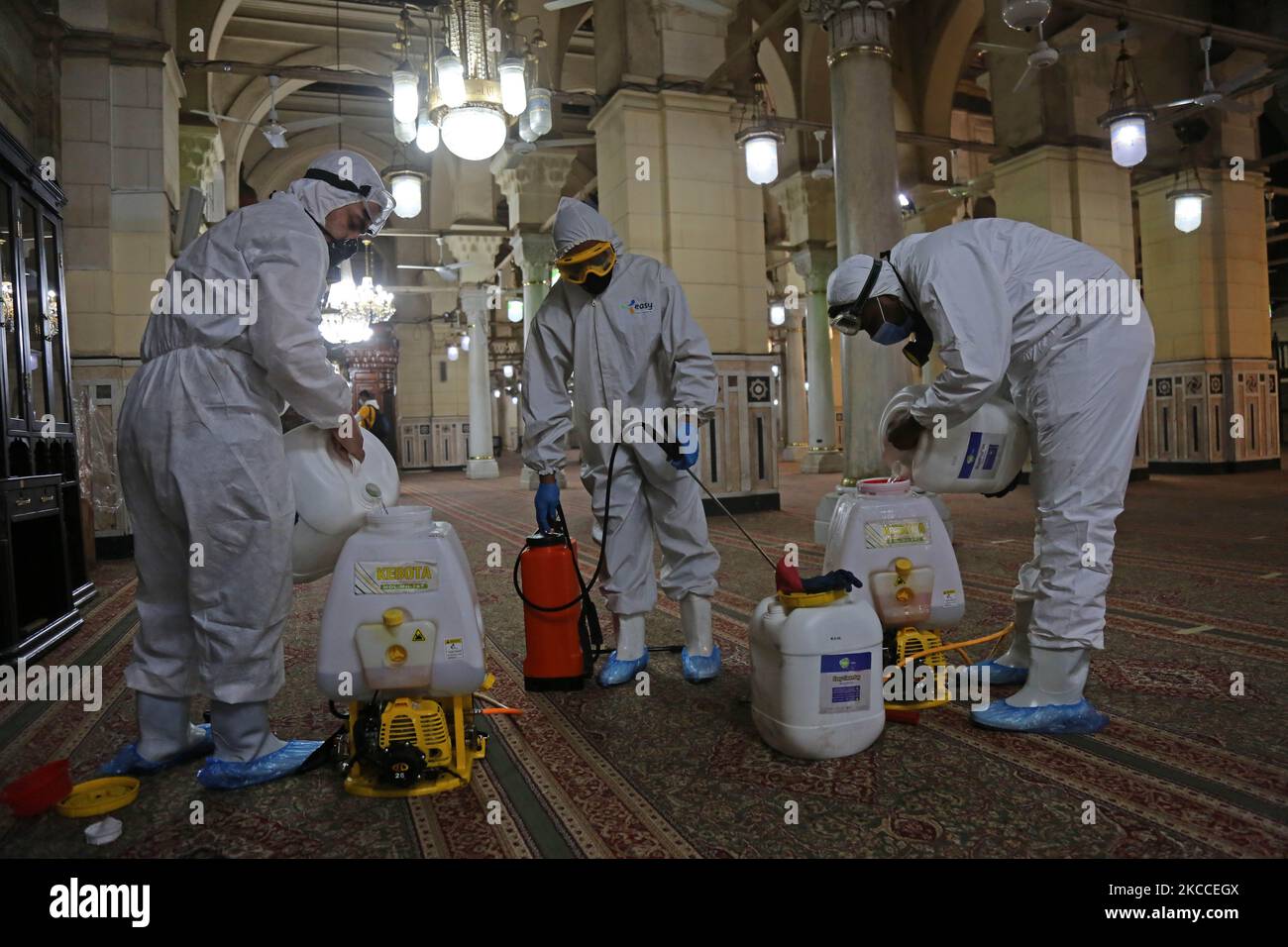 Arbeiter, die Gesichtsmasken tragen, sprühen Desinfektionsmittel, während sie sich während des gesegneten Monats Ramadan in der Sayeda Zeinab Moschee nach dem Ausbruch des Coronavirus (Covid-19) in Kairo, Ägypten, am 9. April 2021 auf das Gebet vorbereiten. (Foto von Fadel Dawod/NurPhoto) Stockfoto