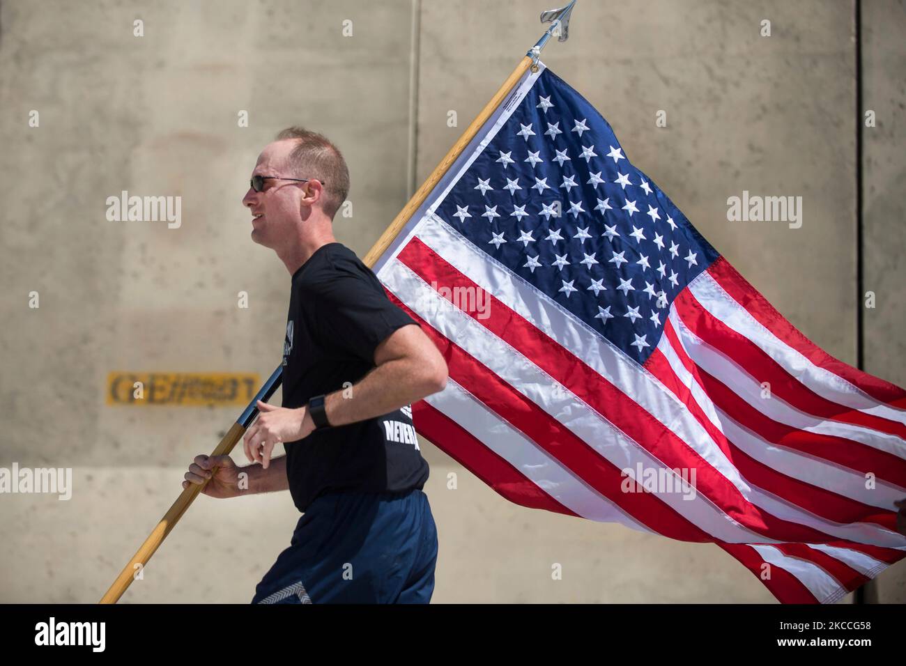 Der Kommandant der US-Luftwaffe trägt die US-Flagge, während er an einem Lauf teilnimmt. Stockfoto