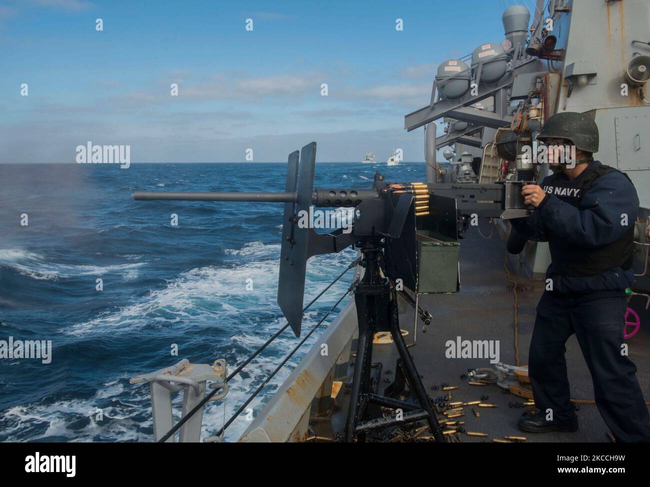 Personnel Specialist feuert ein M2HB 50-Kaliber-Maschinengewehr an Bord der USS the Sullivans. Stockfoto