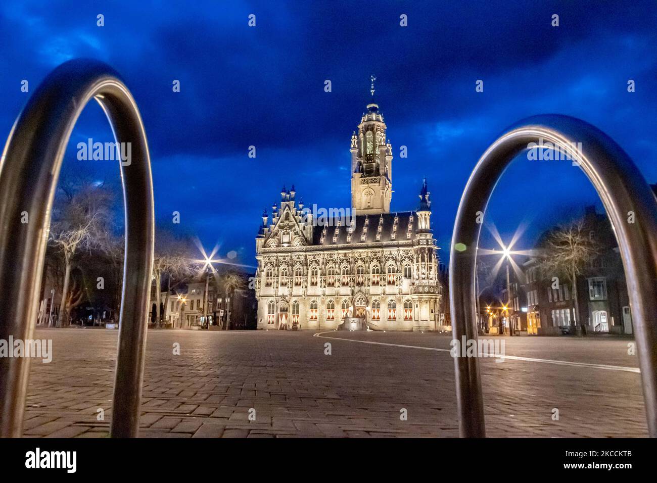 Das beleuchtete, ikonische Rathaus von Middelburg, eine der wichtigsten Sehenswürdigkeiten der Stadt, ist ein Wahrzeichen der Architektur, wie es nach dem Sonnenuntergang während der magischen Stunde der Dämmerung mit dunklen Wolken am Himmel zu sehen ist. Das Stadhuis ist ein Gebäude aus dem 15.-16.. Jahrhundert mit gotischer Architektur, eines der schönsten des Landes. Die Innenräume brannten im Mai 1940 während der Bombardierungen im Zweiten Weltkrieg vollständig ab. Derzeit wird das Gebäude von der Universität genutzt. Middelburg ist die Hauptstadt der niederländischen Provinz Zeeland, ein berühmtes und beliebtes Touristenziel für Einheimische und internationale Touristen Stockfoto