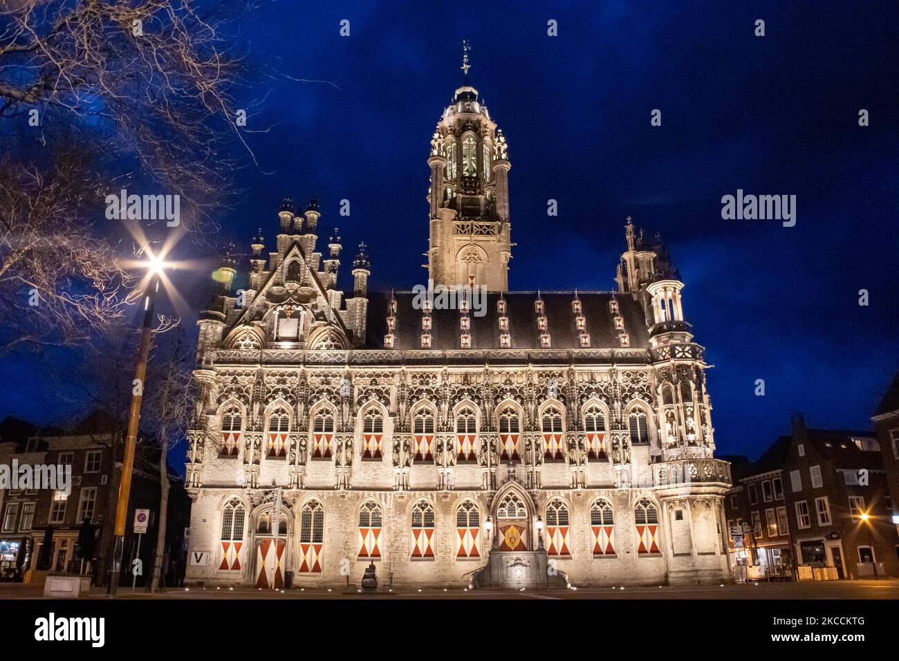 Das beleuchtete, ikonische Rathaus von Middelburg, eine der wichtigsten Sehenswürdigkeiten der Stadt, ist ein Wahrzeichen der Architektur, wie es nach dem Sonnenuntergang während der magischen Stunde der Dämmerung mit dunklen Wolken am Himmel zu sehen ist. Das Stadhuis ist ein Gebäude aus dem 15.-16.. Jahrhundert mit gotischer Architektur, eines der schönsten des Landes. Die Innenräume brannten im Mai 1940 während der Bombardierungen im Zweiten Weltkrieg vollständig ab. Derzeit wird das Gebäude von der Universität genutzt. Middelburg ist die Hauptstadt der niederländischen Provinz Zeeland, ein berühmtes und beliebtes Touristenziel für Einheimische und internationale Touristen Stockfoto