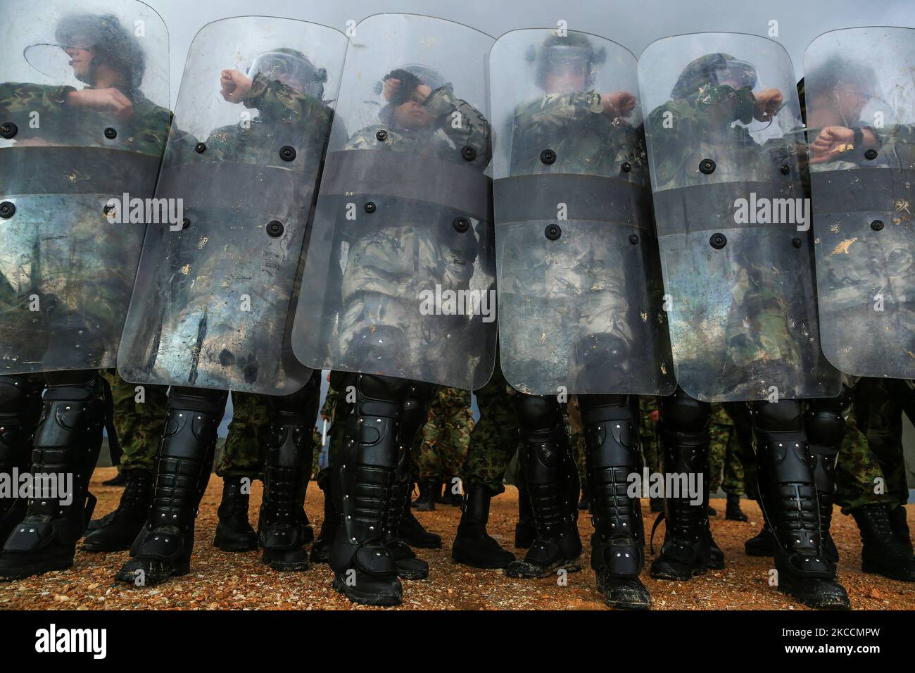 Bulgarische und serbische Soldaten legen die Ausrüstung für die Aufstandskontrolle an. Stockfoto