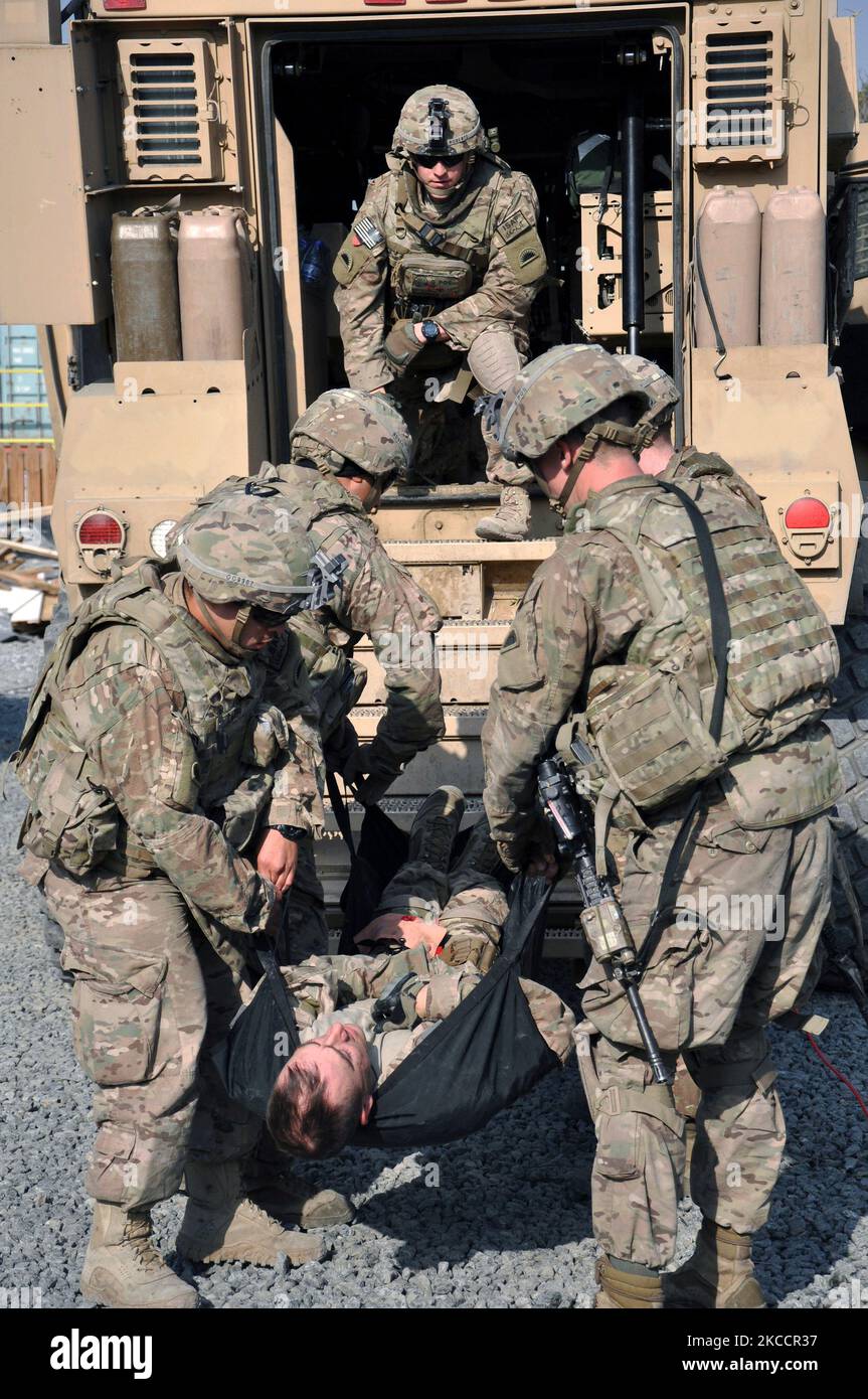 Soldaten der US-Armee üben das Heben eines verletzten Soldaten in den Rücken eines taktischen Fahrzeugs. Stockfoto