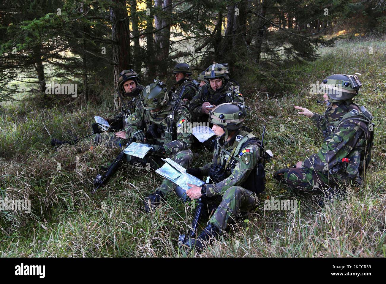 Rumänische Soldaten diskutieren, welchen Weg sie nehmen sollen, während sie eine abgemountete Patrouille führen. Stockfoto