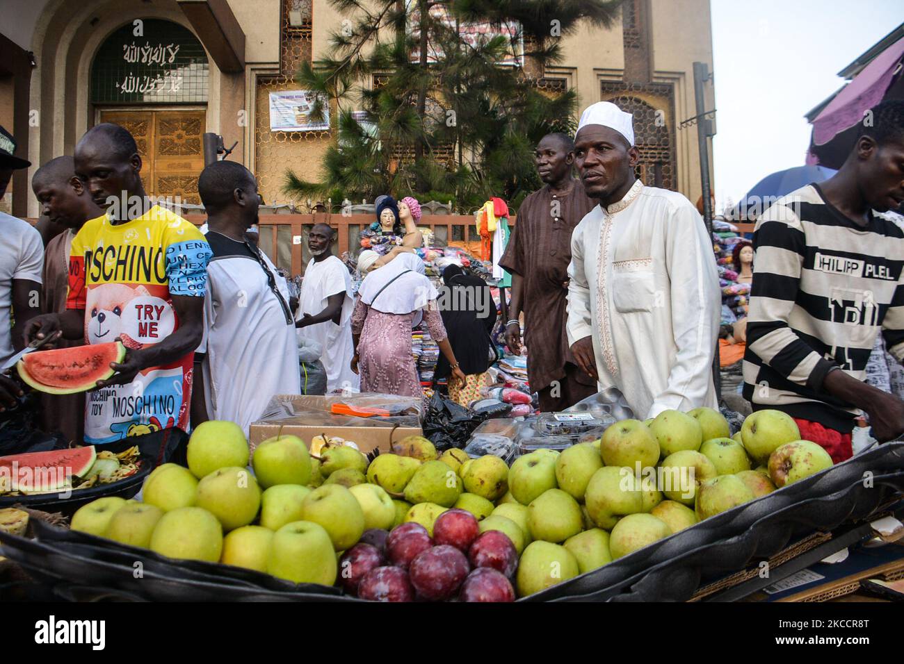 Ein Straßenhändler verkauft Wassermelonen/Apfel, während er am Eingang der zentralen Moschee von Lagos (Insel Lagos) entlang der geschäftigen Nnamdi Azikiwe Street in Lagos, Nigeria, am 14. April 2021 auf Kunden wartet. Muslime markierten den Beginn des Ramadan am Dienstag, der Ramadan ist geprägt von langen Gebeten, bis in die Abenddämmerung dauernden Fasten und nächtlichen Festen mit Familie und Freunden, obwohl überfüllte Schulter-an-Schulter-Treffen in der Moschee und große Treffen zu Mahlzeiten aufgrund der anhaltenden Verbreitung von COVID-19 weiterhin verboten sind. (Foto von Olukayode Jaiyeola/NurPhoto) Stockfoto