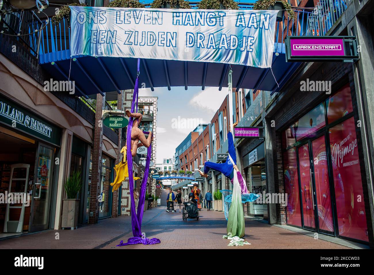 Zwei Luftakrobaten treten mit Luftseide mitten im Stadtzentrum auf, während einer Aktion, die vom Extinction Rebellion in Nijmegen am 16.. April 2021 durchgeführt wurde. (Foto von Romy Arroyo Fernandez/NurPhoto) Stockfoto