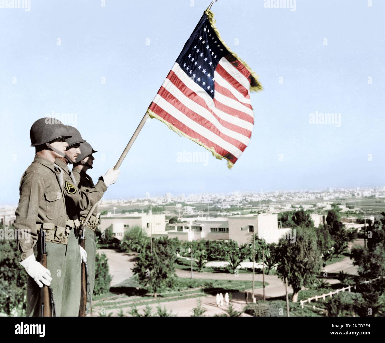 Drei Soldaten stehend mit US-Flagge mit Blick auf die Villa in Casablanca, Marokko, 1943. Stockfoto