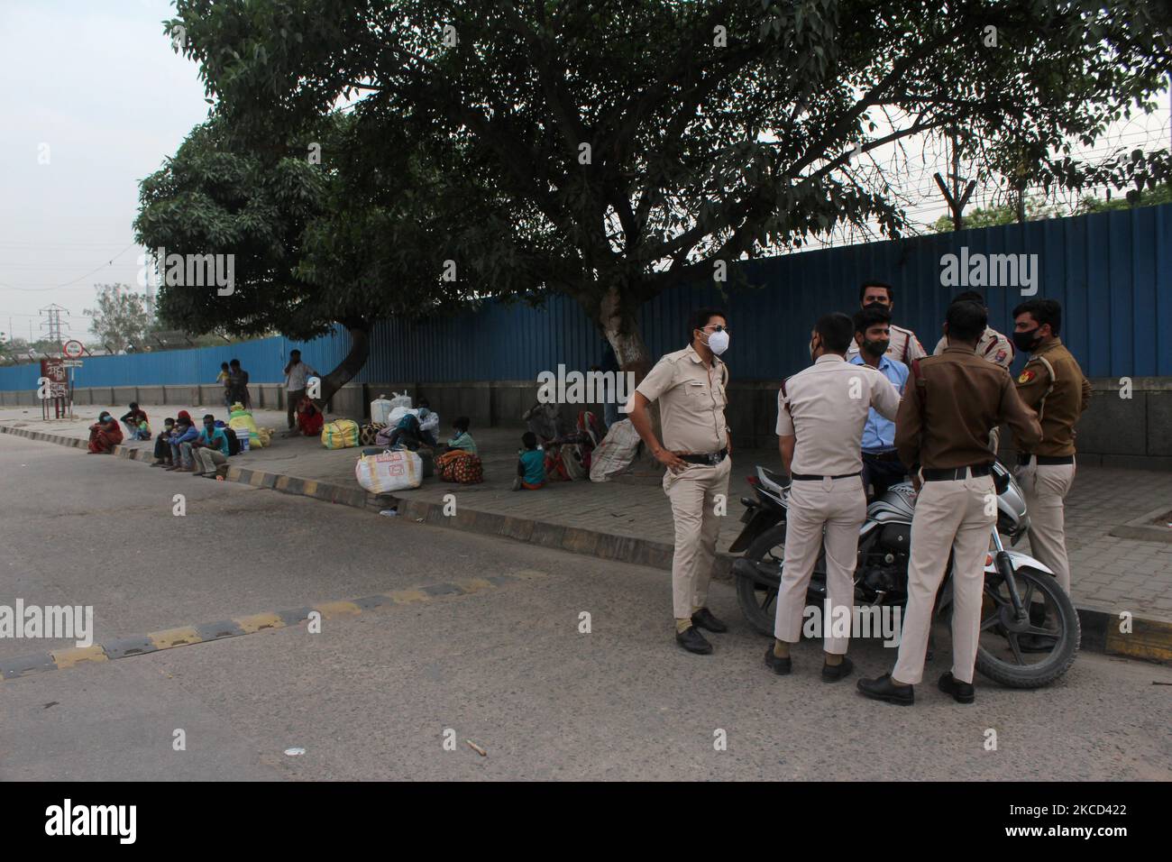 Freiwillige im Zivilschutz sind an einem Busbahnhof stationiert, als Wanderarbeiter nach einer sechstägigen Ausgangssperre, die am 20. April 2021 in Neu Delhi eingerichtet wurde, um die Ausbreitung von Coronavirus-Infektionen einzudämmen, auf die Abfahrt von Bussen in ihre jeweiligen Dörfer warten. Indien verzeichnet jetzt mehr als 2 Millionen (20 lakh) offiziell aktive Fälle von Covid-19, der derzeit zweithöchsten Zahl der Welt nach den USA. (Foto von Mayank Makhija/NurPhoto) Stockfoto