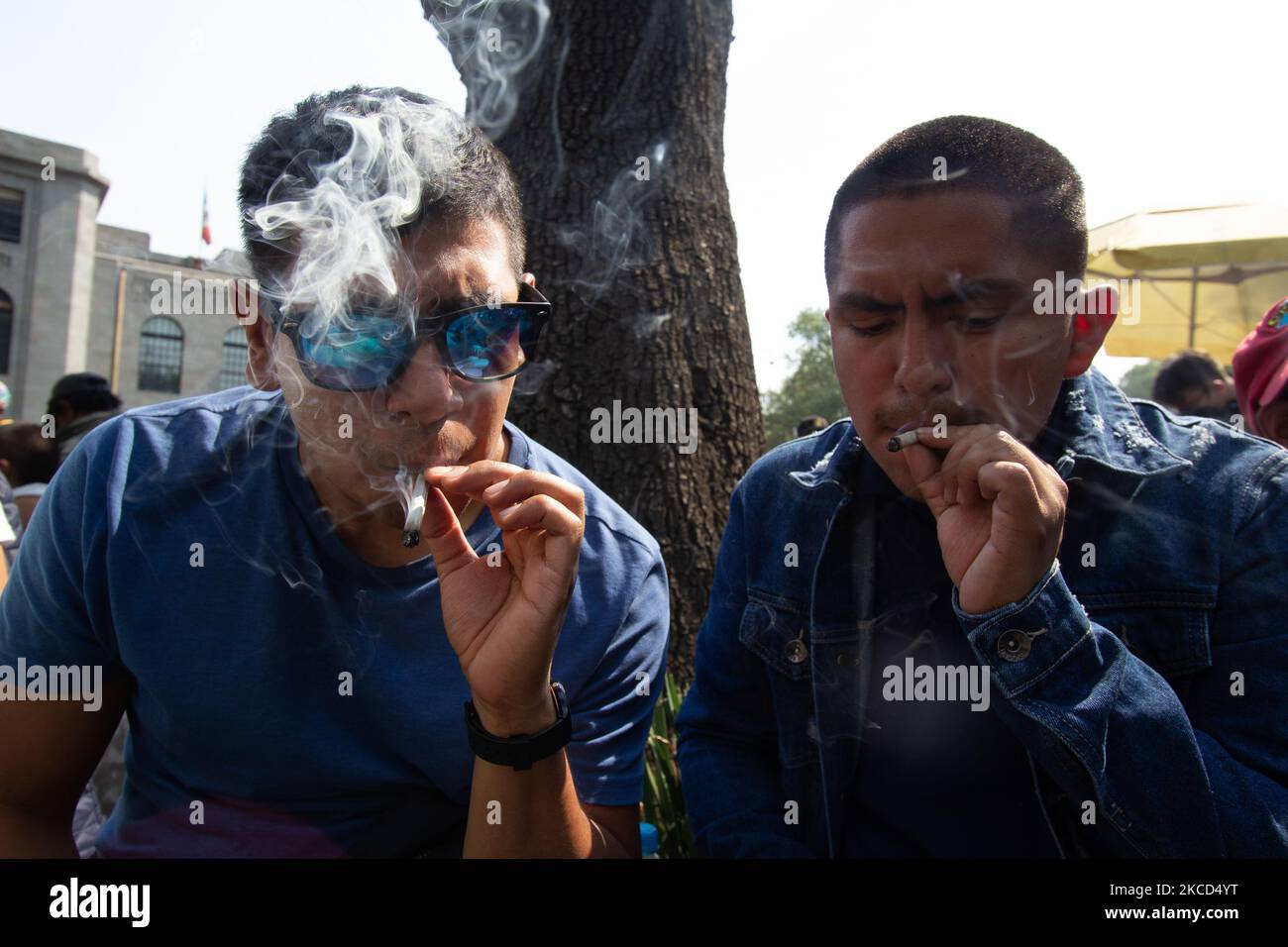 Zwei Männer rauchen einen Joint während einer Demonstration, die die Legalisierung von Marihuana für den Freizeitkonsum im Rahmen des Internationalen Marihuana-Tages in Mexiko-Stadt, Mexiko, am 20. April 2021 forderte. Verschiedene Gruppen für die Legalisierung von Cannabis demonstrierten durch Märsche, Sit-ins und eine Reihe von künstlerischen und Freizeitaktivitäten in verschiedenen Teilen von Mexiko-Stadt.ebenso wurde unter anderem das sogenannte Fumaton 420 in der Demonstration am Rande des Senats der Republik durchgeführt.(Foto: Martin Gorostiola/NurPhoto) Stockfoto