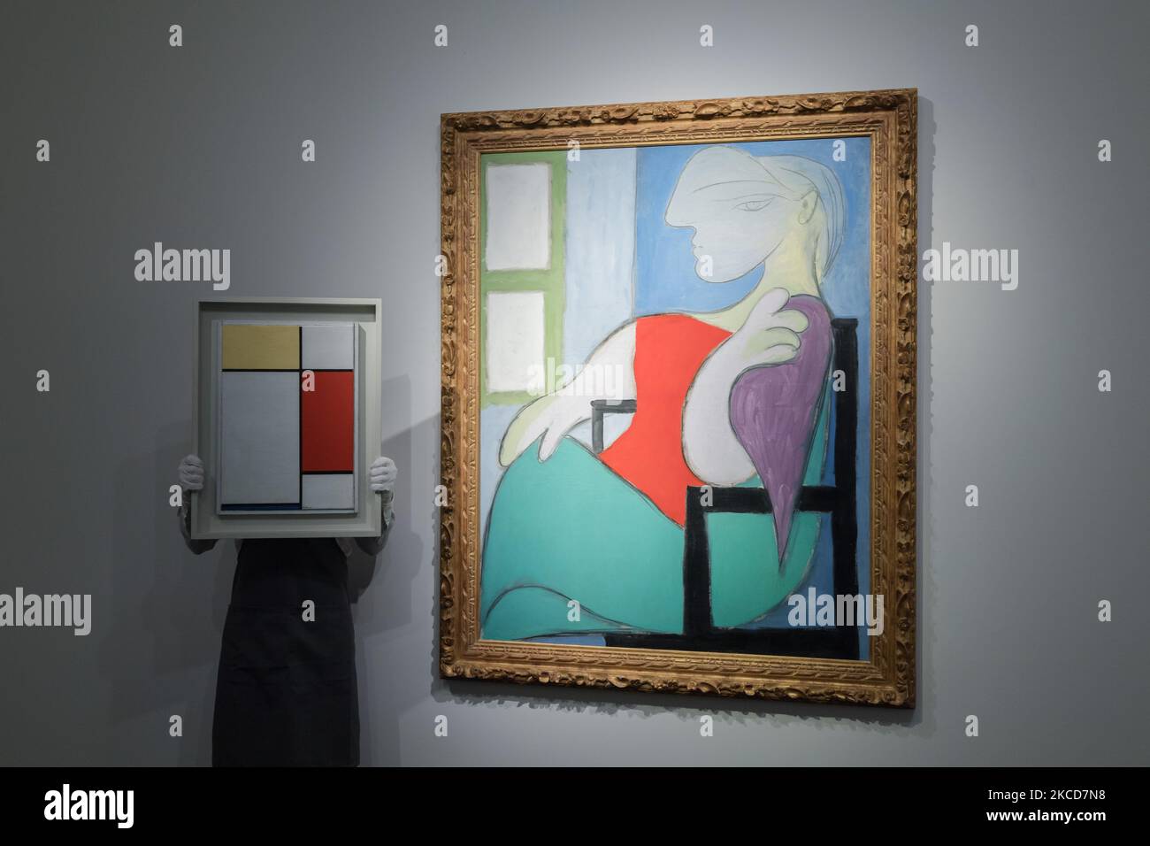 LONDON, VEREINIGTES KÖNIGREICH - 22. APRIL 2021: Ein Mitarbeiter posiert mit dem Öl „Femme Assise Pres d'une Fenetre“ (Marie-Thérèse) auf einer Leinwand von Pablo Picasso (1881-1973), Eigentum eines bedeutenden Privatsammlers, Schätzung auf Anfrage (im Bereich von $55 Millionen) (rechts) und „Komposition: Nr. II, mit Gelb, Red and Blue' (1927) Öl auf Leinwand von Piet Mondrian (1872-1944), Immobilie aus einer bedeutenden Privatsammlung, Schätzung auf Anfrage (in der Region von $25 Millionen) (links) während eines Fotoaufrufs der Highlights der New Yorker Frühjahrssaison der Abendverkäufe bei Christie's Auktionshaus in London, o Stockfoto