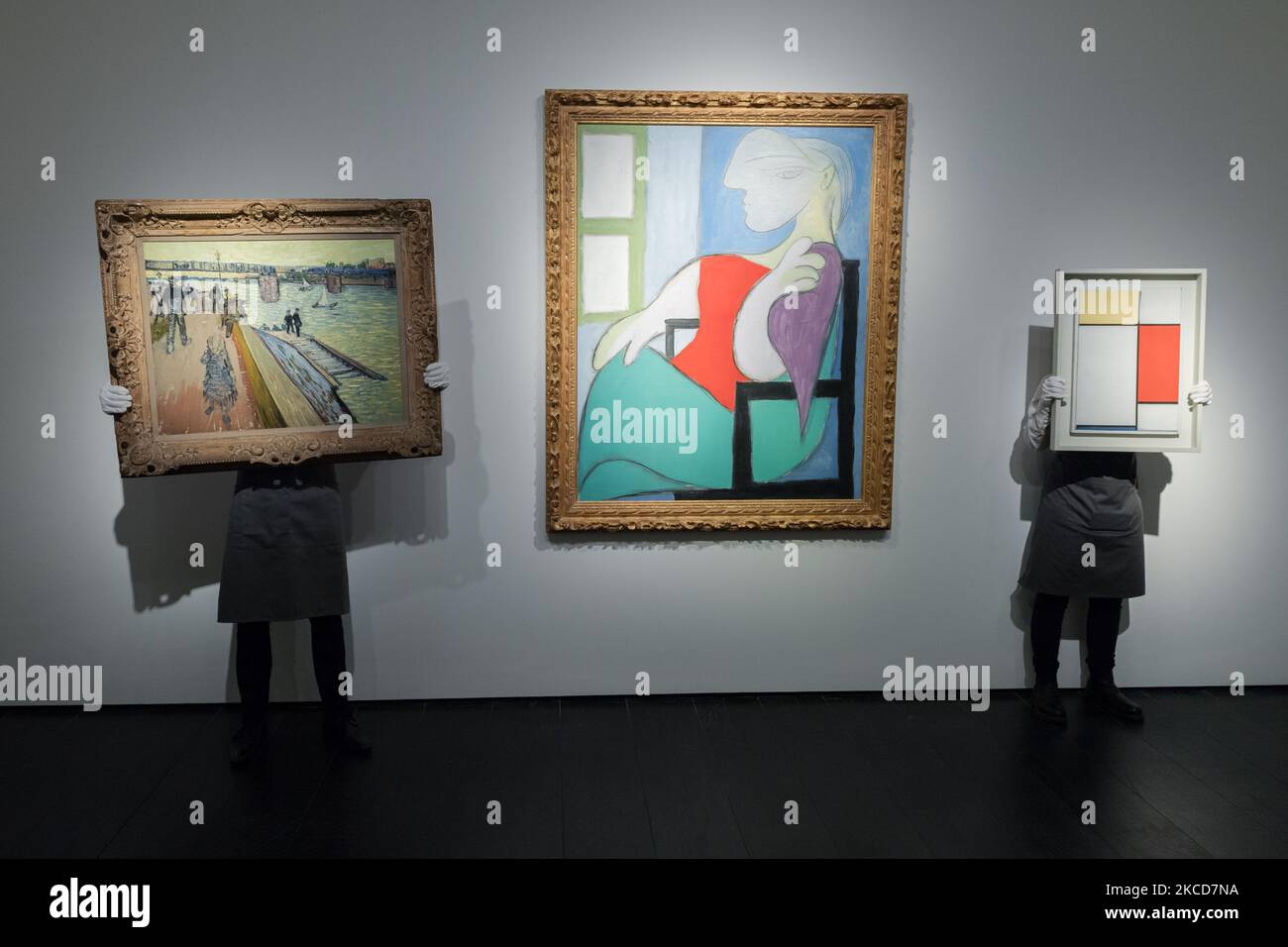LONDON, GROSSBRITANNIEN - 22. APRIL 2021: Mitarbeiter posieren mit dem Öl „Le pont de Trinquetaille“ (1888) auf Leinwand von Vincent van Gogh (1853-1890), Eigentum eines bedeutenden europäischen Sammlers, Schätzung: 25.000.000-35.000.000 Dollar (links), 'Femme Assise Pres d'une Fenetre' (Marie-Thérèse) Öl auf Leinwand von Pablo Picasso (1881-1973), Eigentum eines bedeutenden privaten Sammlers, Schätzung auf Anfrage (in der Region von $55 Millionen) (Mitte) und 'Komposition: Nr. II, mit Gelb, Rot und Blau' (1927) Öl auf Leinwand von Piet Mondrian (1872-1944), Besitz aus einer bedeutenden Privatsammlung, Schätzung auf Anfrage Stockfoto