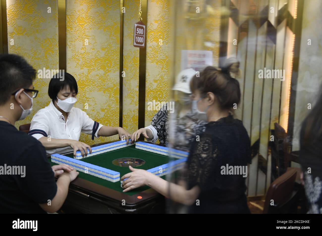 Menschen mit Gesichtsmasken spielen am 28. April 2021 in einer Mahjong Hall in Hongkong, China, Mahjong. Hongkong hat seine Mahjong Hall über acht Monate geschlossen und wird morgen wieder eröffnet. Hongkong hat begonnen, seine Covid-19-Beschränkungen zu lockern, nachdem Hongkong neue Fallzahlen bei Low Case gesehen und sein Impfprogramm gestartet hat. (Foto von Vernon Yuen/NurPhoto) Stockfoto