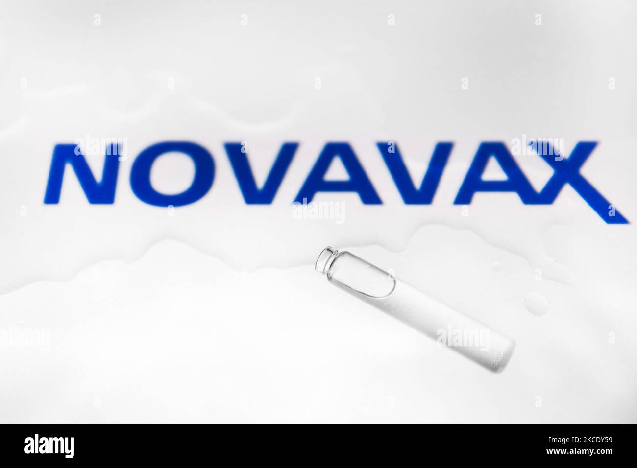 Das Logo des Impfstoffherstellers von Novavax wird mit einem Fläschchen fotografiert und verschüttete Flüssigkeit als Illustration aufgenommen. Krakau, Polen, am 5.. Mai 2021. Innerhalb von weniger als 12 Monaten nach Beginn der COVID-19-Pandemie haben sich mehrere Forscherteams der Herausforderung gestellt und Impfstoffe entwickelt, die vor SARS-CoV-2, dem Virus, das COVID-19 verursacht, schützen. (Foto von Beata Zawrzel/NurPhoto) Stockfoto