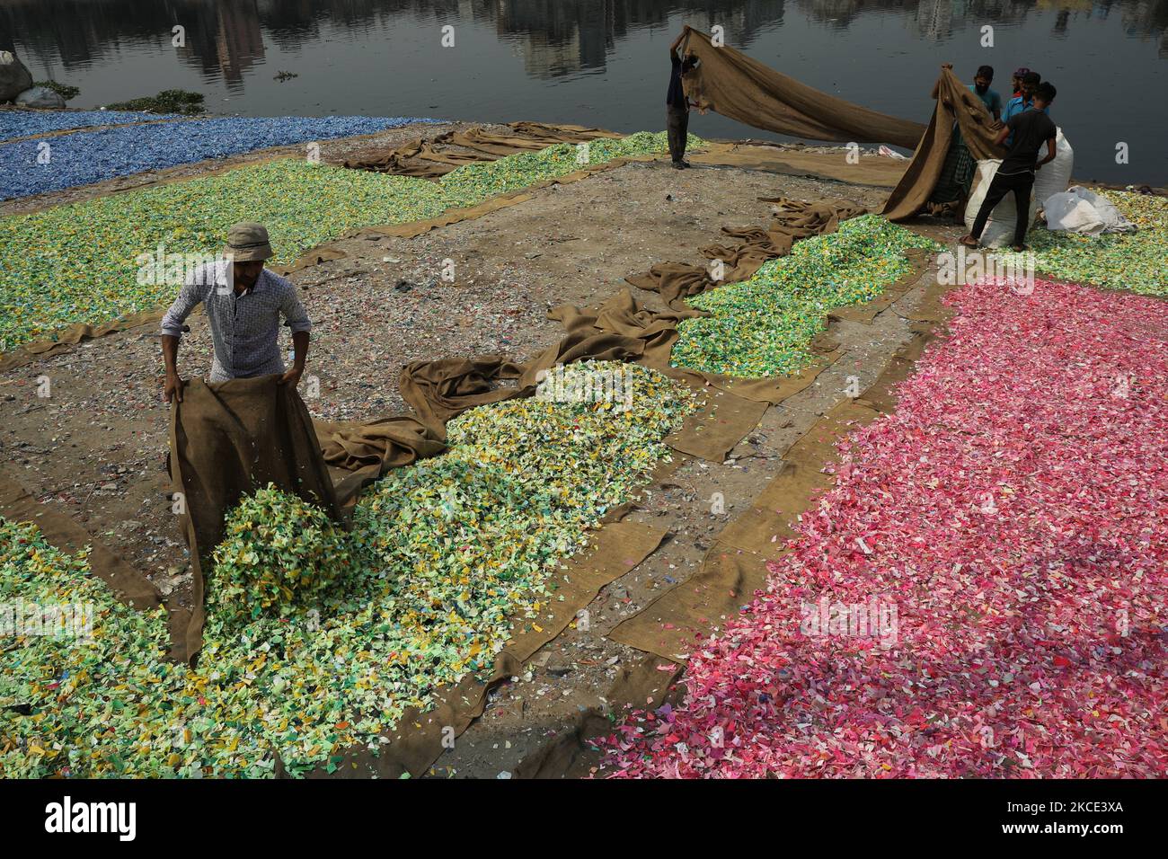Nach dem Waschen am 05. Mai 2021 im Fluss Buriganga in Dhaka, Bangladesch, verbreiteten Arbeiter recycelte Plastikspäne. Der Buriganga-Fluss, der durch die Stadt Dhaka fließt, ist heute einer der am stärksten verschmutzten Flüsse der Welt, weil dort Menschen und Industrieabfällen in die Luft gedumpt werden. (Foto von Syed Mahamudur Rahman/NurPhoto) Stockfoto