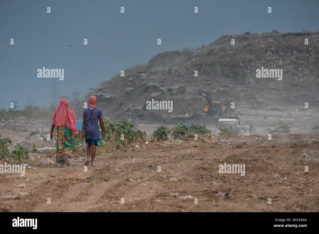 Die Arbeiter gehen am 7. Mai 2021 in Kalkutta, Indien, durch eine Deponie mit Müllbergen im Hintergrund. (Foto von Debarchan Chatterjee/NurPhoto) Stockfoto