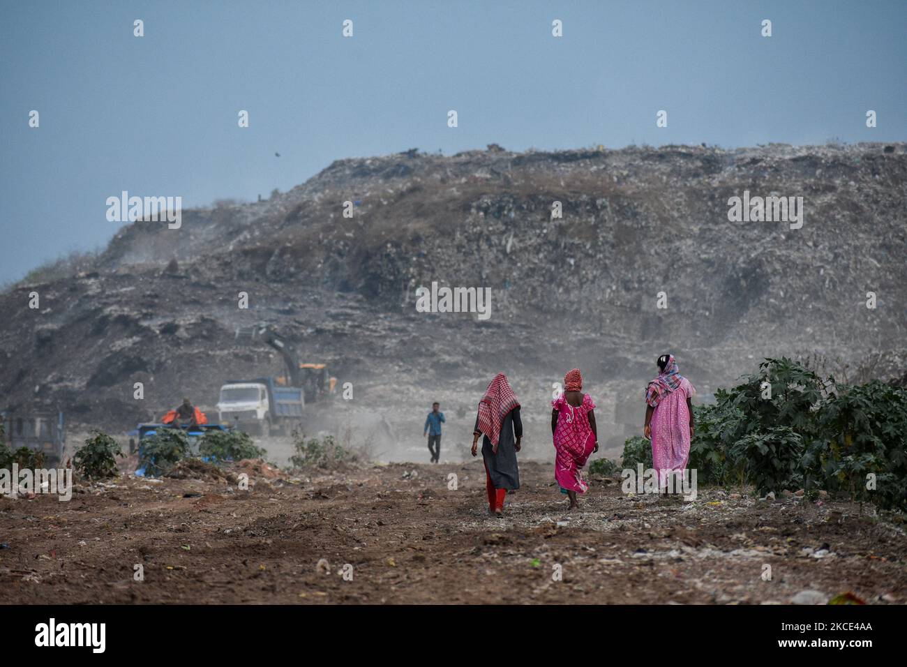Drei Mädchen gehen am 7. Mai 2021 in Kalkutta, Indien, durch eine Deponie mit Müllbergen im Hintergrund. (Foto von Debarchan Chatterjee/NurPhoto) Stockfoto
