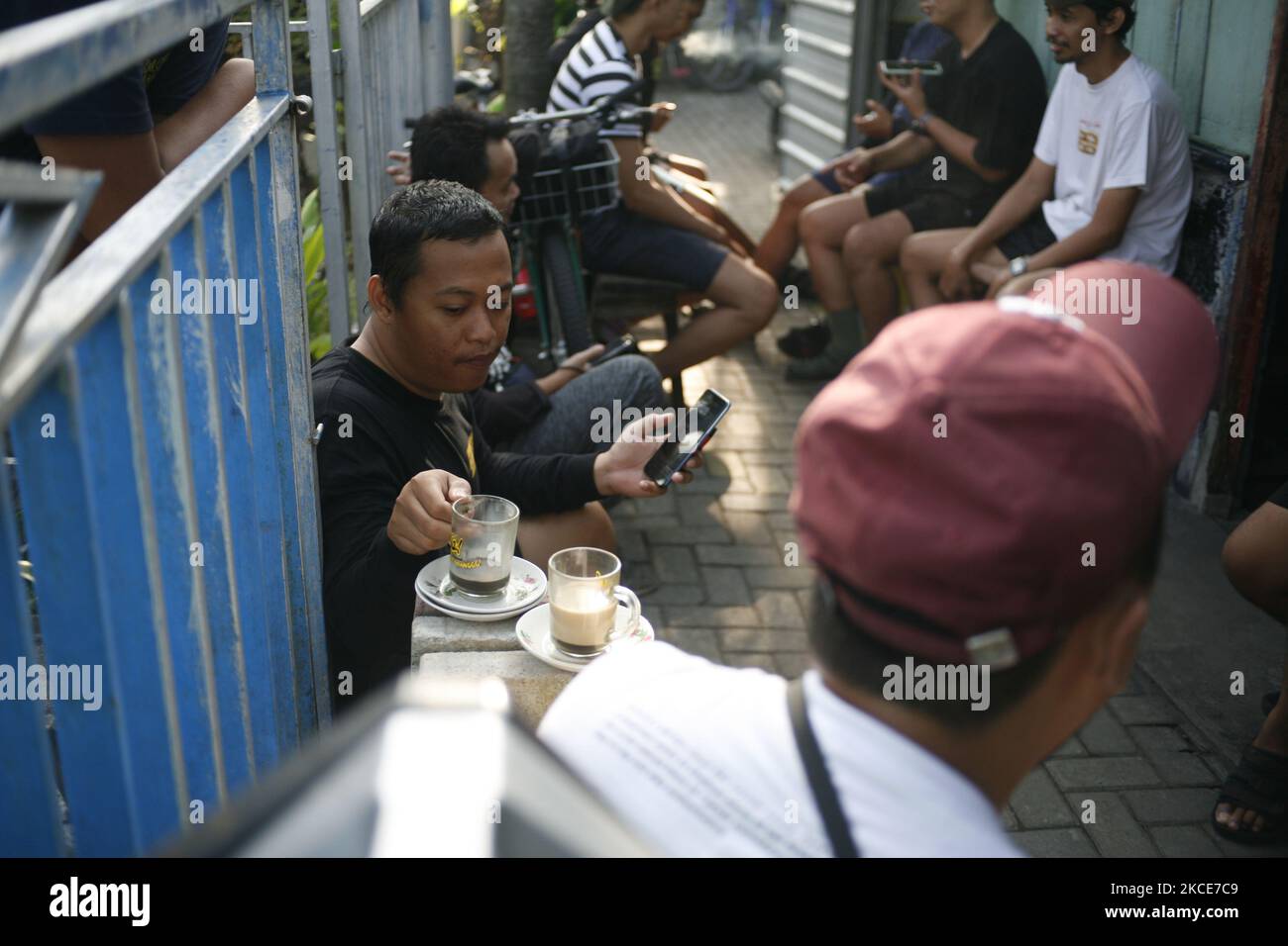 Asiatische Gruppe von Freunden, die in einem traditionellen Café oder Restaurant namens Warung in Kediri, Eastjava, Indonesien, rumhängen. Stockfoto