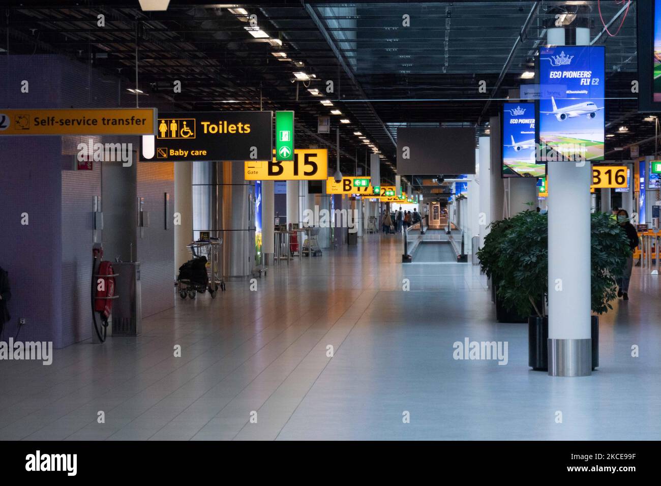 Während der Pandemie von Covid-19 ist der Bereich der Abflugtore im Terminal des internationalen Flughafens Amsterdam Schiphol fast leer. Die Anzahl der Passagiere und die Crew tragen Schutzausrüstung wie die obligatorischen Gesichtsmasken und Handschuhe, um die Ausbreitung des Coronavirus zu vermeiden. Die Zahl der Passagiere im Weltflug sank aufgrund der Reisebeschränkungen, Sicherheitsmaßnahmen wie Sperren, Quarantäne, PCR und Schnelltests vor den Flügen während der Ära der Coronavirus-Pandemie Covid-19, die die Luft- und Reisebranche schwer getroffen hatte. Amsterdam Stockfoto